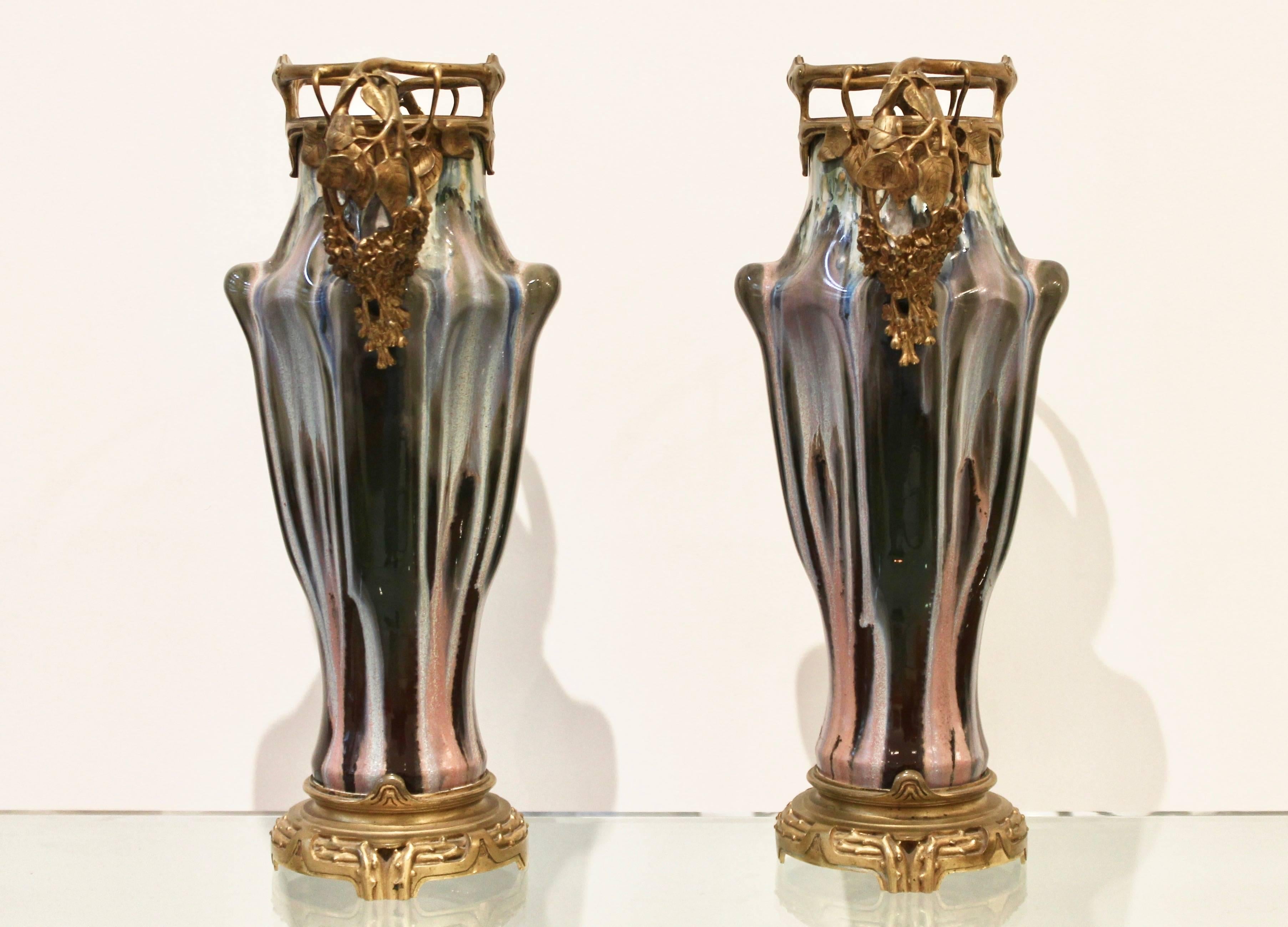 Paul Louchet (1854-1936).

Pair of earthenware Art Nouveau vases, circa 1900.
Glazed earthenware, chiseled gilt bronze.
Louchet seal on base.

Pair of vases in earthenware, decor of purple and pink streaks on brown and brick red background.
