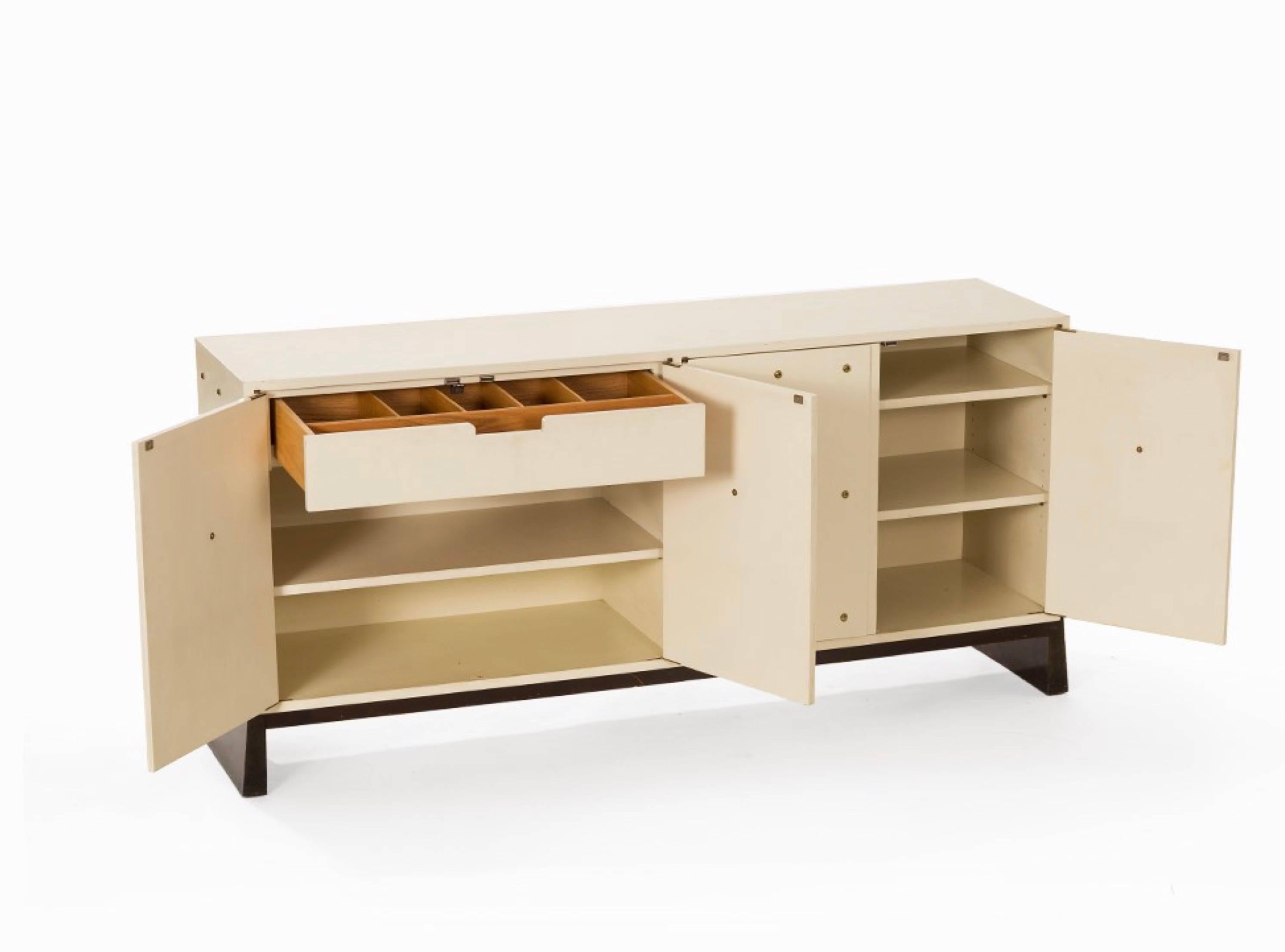 Iconic studded white sideboard by Tommi Parzinger for Parzigner Originals. This model features four doors with adjustable shelves as well as a felt-lined interior drawer. Brand signed in that drawer.
  