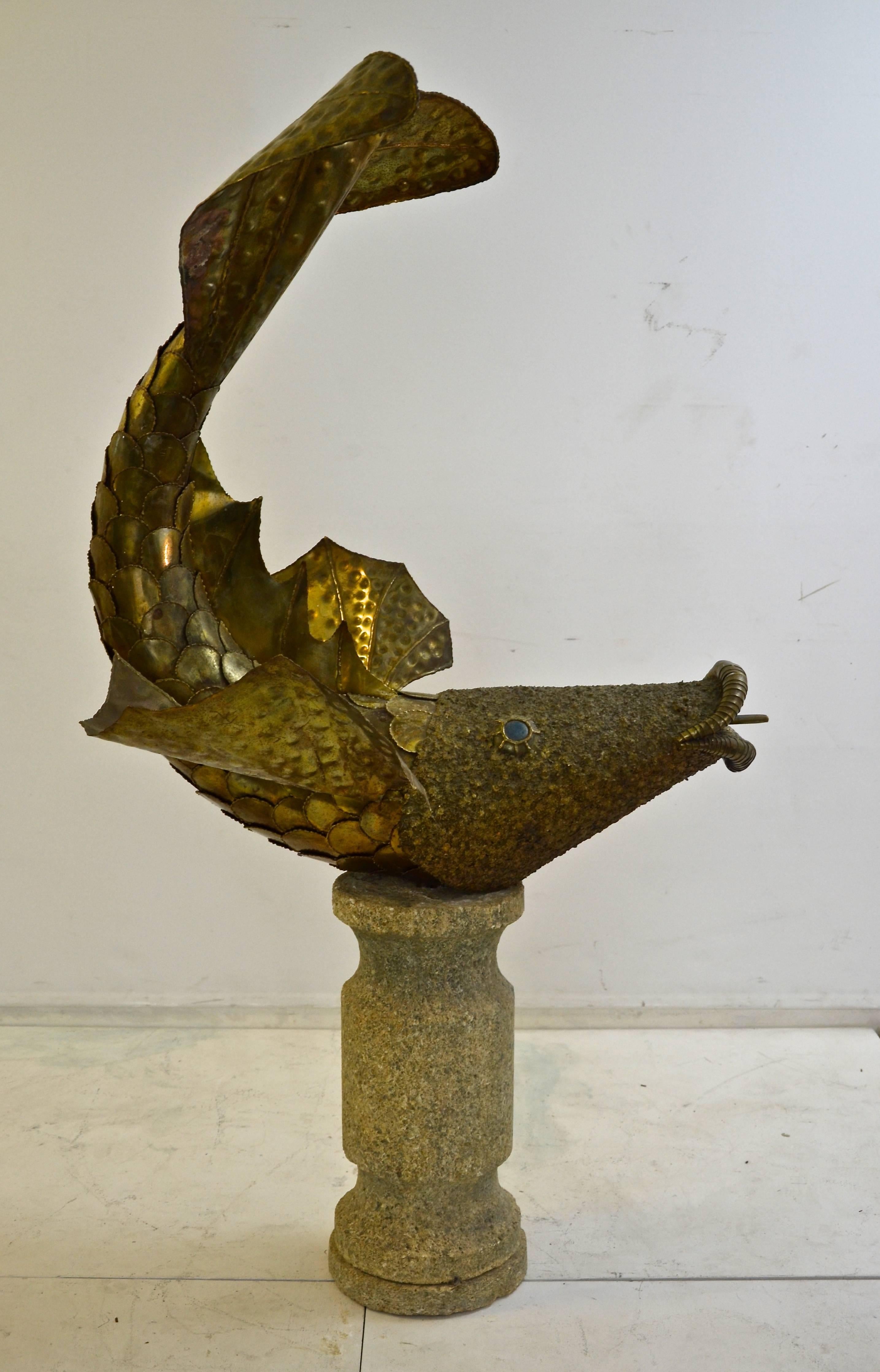 Decorative 1970s fish fountain in brass on stone pedestal.