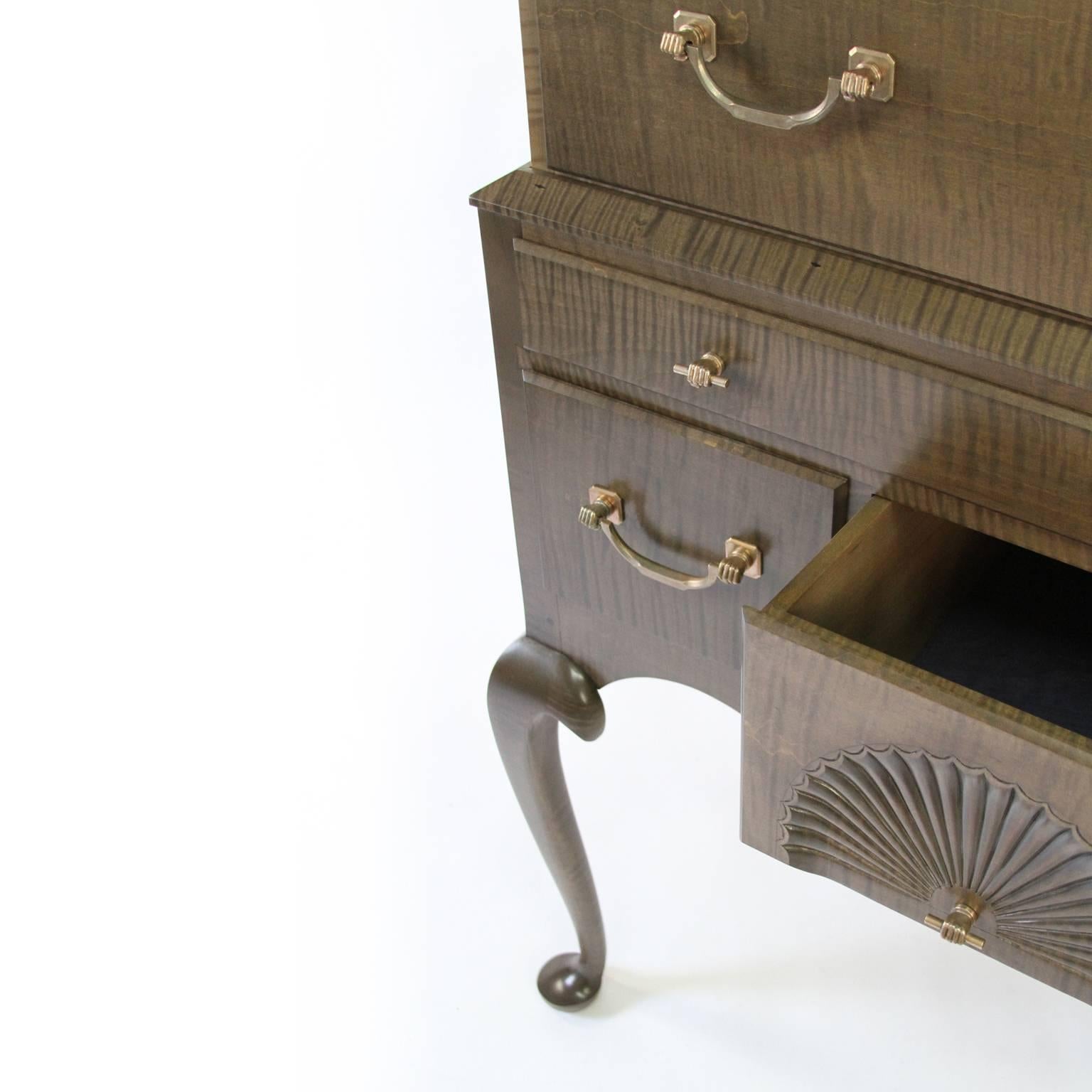 O&G Studio's take on the 18th century Connecticut style highboy. This piece combines a stunning signature stain finish over solid tiger maple. Other details include hand-carved fans and legs, dovetailed drawers and custom O&G bronze fist hardware. A