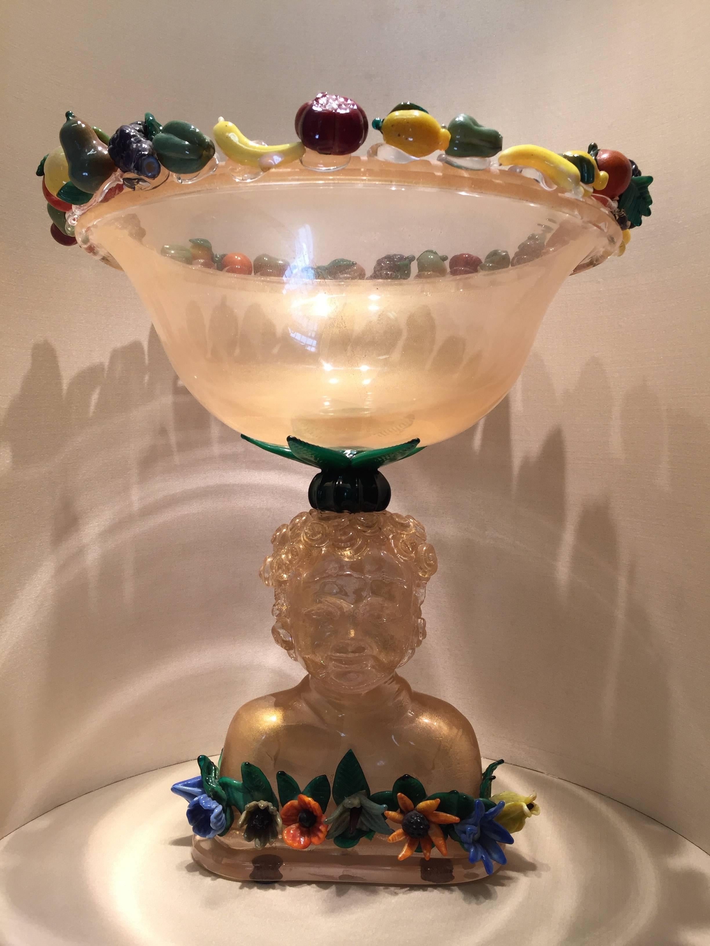 An amazing and one of a kind Murano glass with 24-karat gold leaf sculpture with putto, glass jacketed fruits and flowers on the base and on top of the bowl. This beautiful sculpture is made by the great glass maker Pino Signoretto in 1995.

Pino