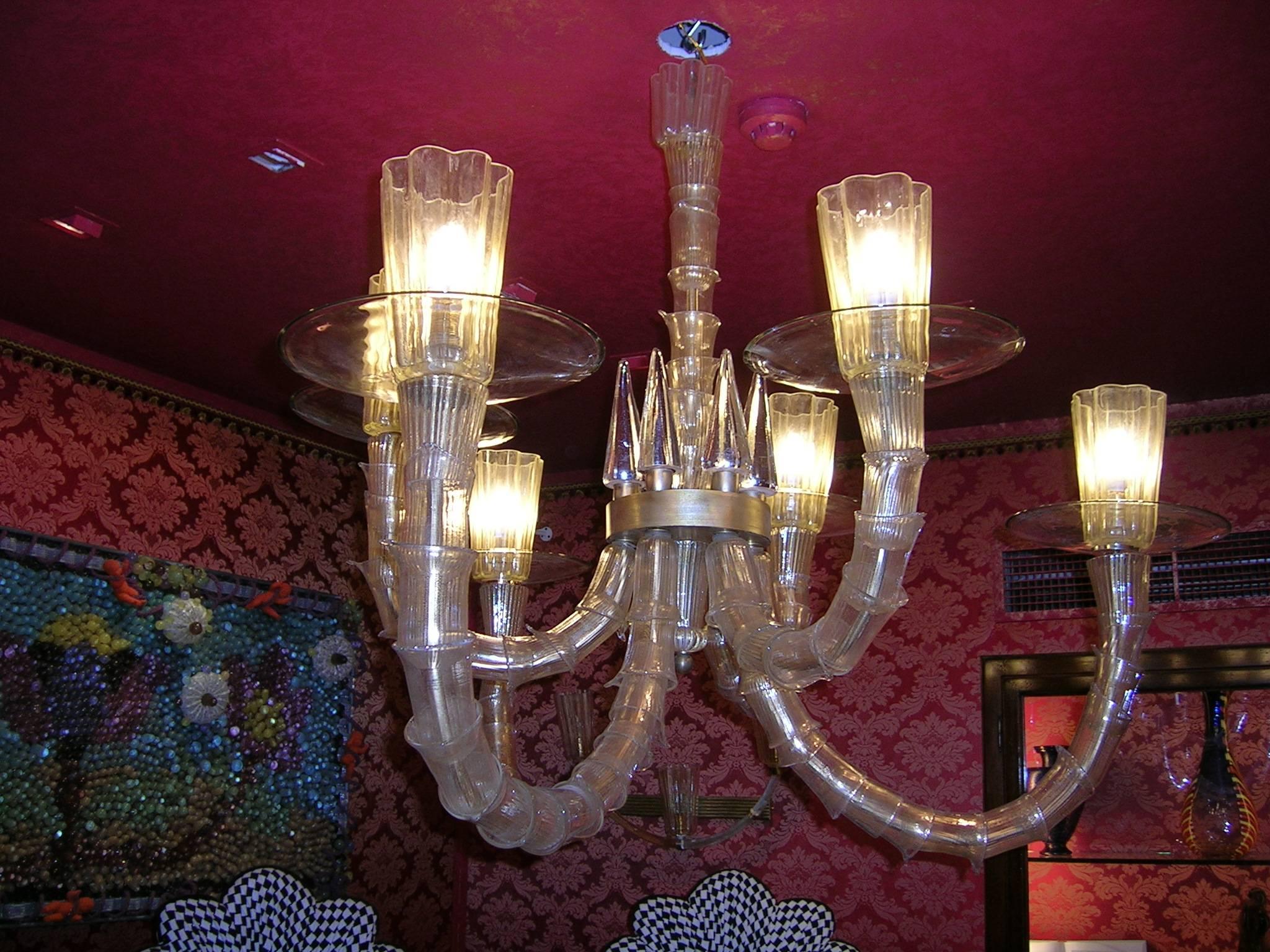 An amazing and probably one of a kind six arms chandelier in "Rezzonico" style mounted in a brass structure with six clear glass cones on the stem.