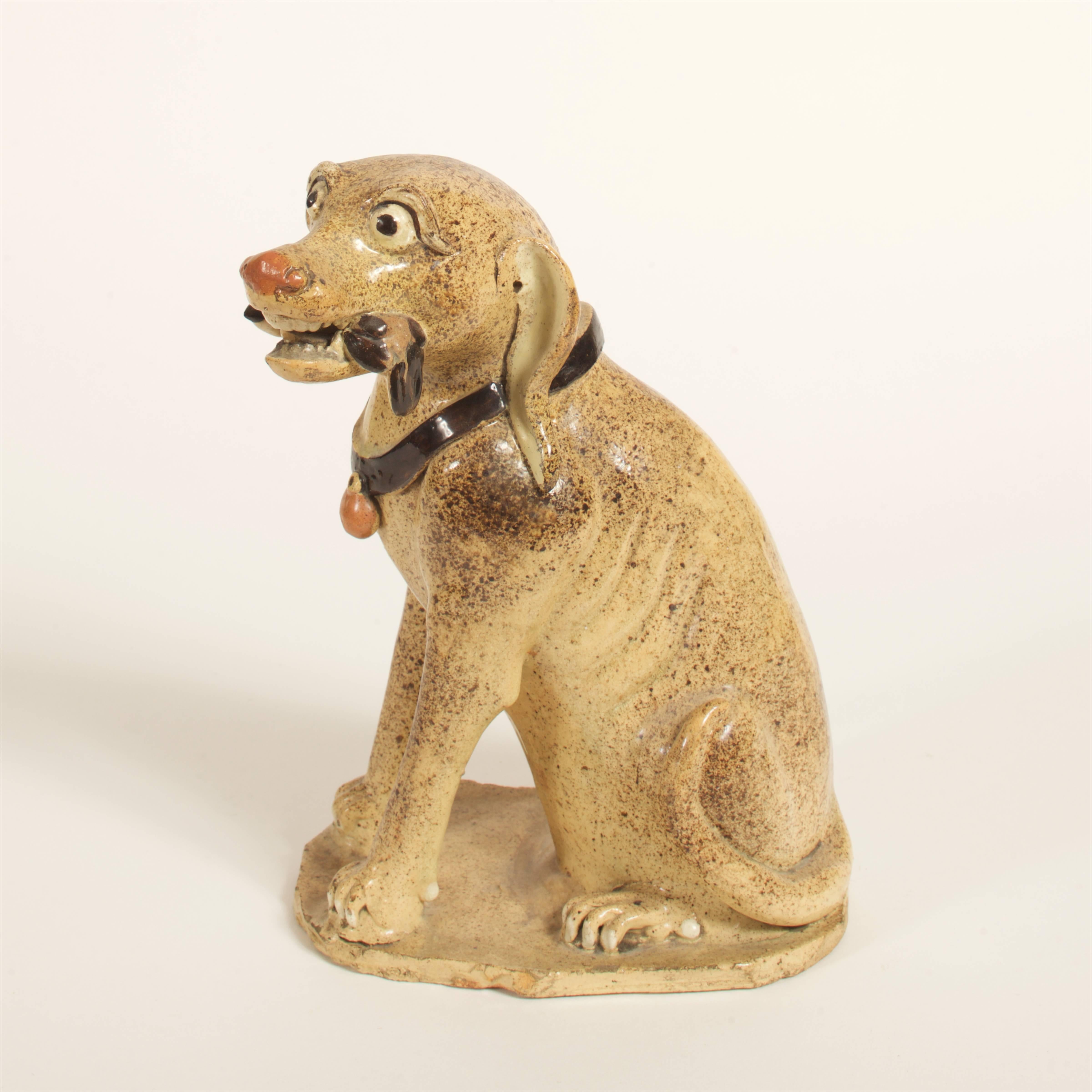 Japanese late Edo period tan glazed pottery seated hound, with quail in his mouth, 10" high.