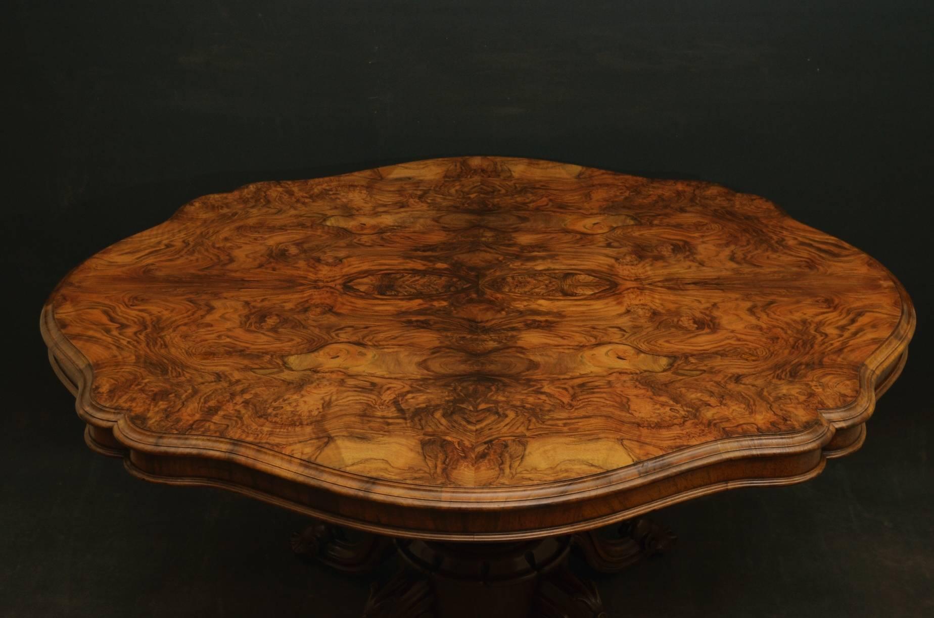 Sn3599, magnificent Victorian, figured walnut centre table, with beautifully figured shaped, tilt top and moulded edge, standing on vase shaped fluted column terminating in four carved cabriole legs and original brass castors. This fine example of