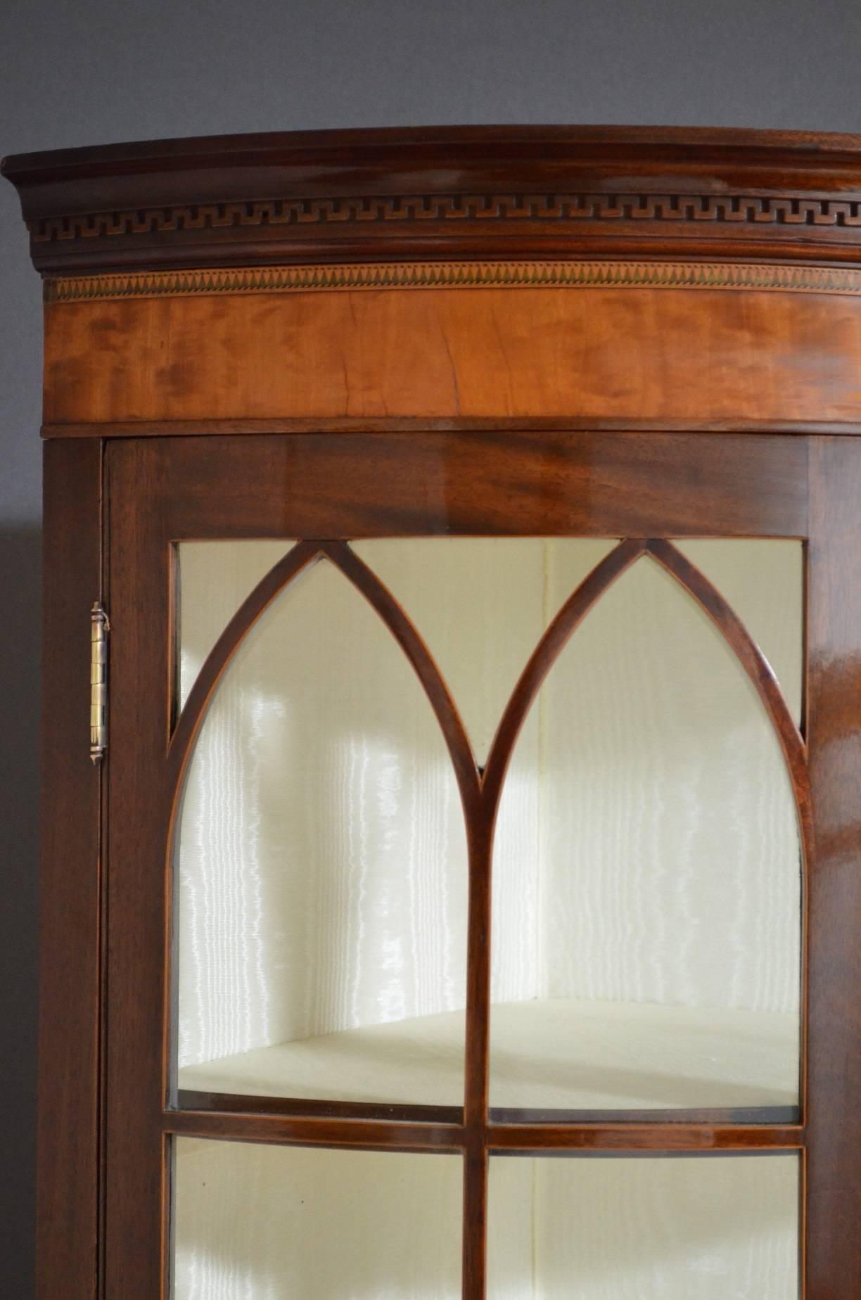 Sn4028, a fine quality and very rare Edwardian, mahogany and inlaid corner cabinet, having cavetto cornice with Greek key carving and satinwood banded frieze above a pair of glazed convex doors enclosing clean relined interior with two shelves, the