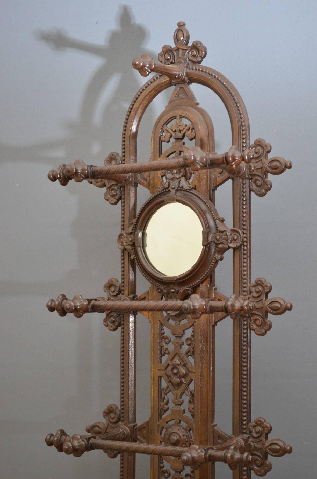 Sn3889 A stylish Victorian, cast iron hall stand / coat stand, having intricate pierced design with circular mirror and coat hooks, supported on fluted uprights with umbrella and stick holders and removable drip tray to base. This Victorian hall