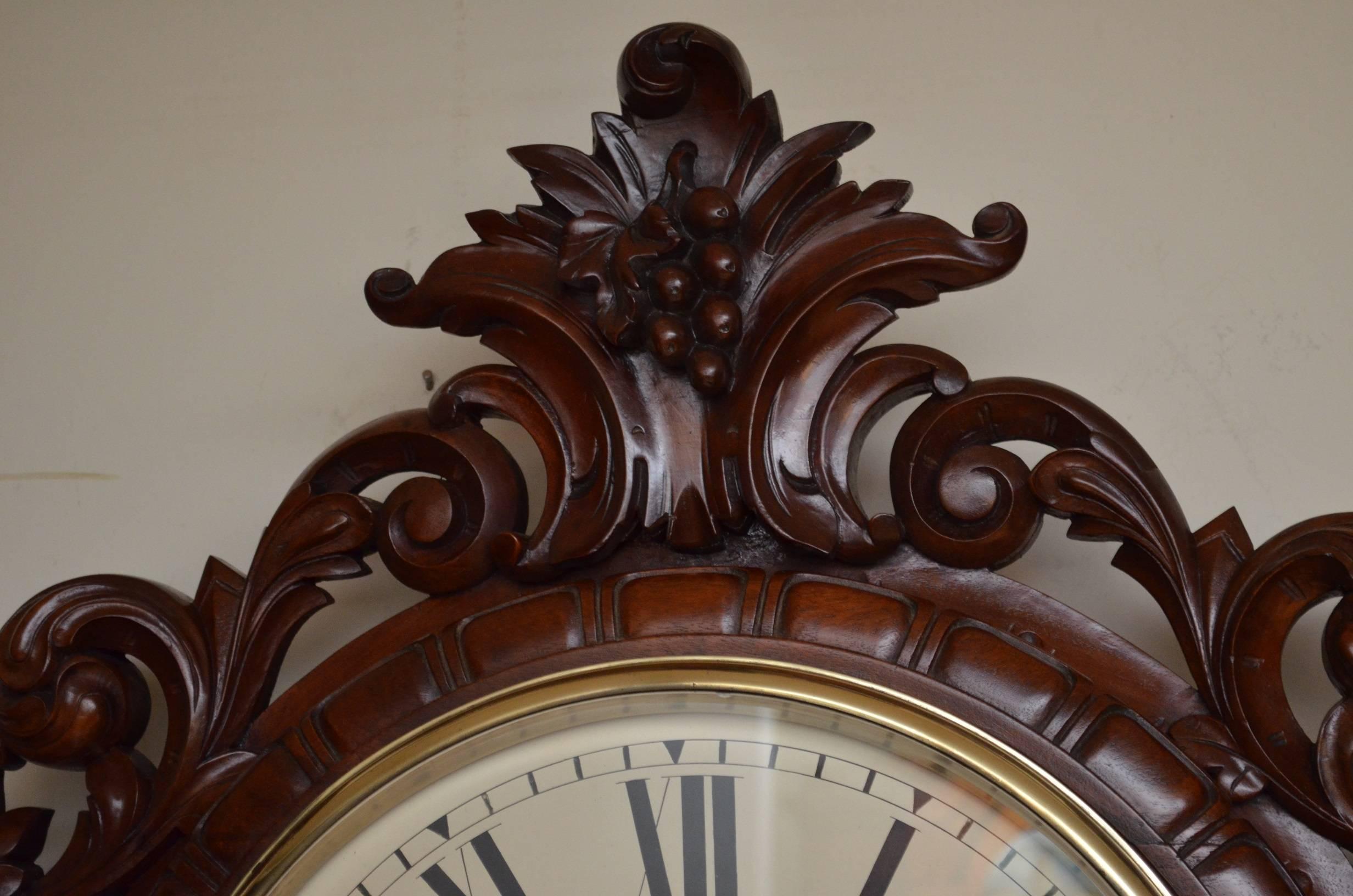 Stunning quality Victorian, mahogany wall clock, having enamel dial with Roman numeral, original hands, brass bezel and single train driven, and fusee movement. The case having finely carved intricate, scrolled decoration throughout and it retains
