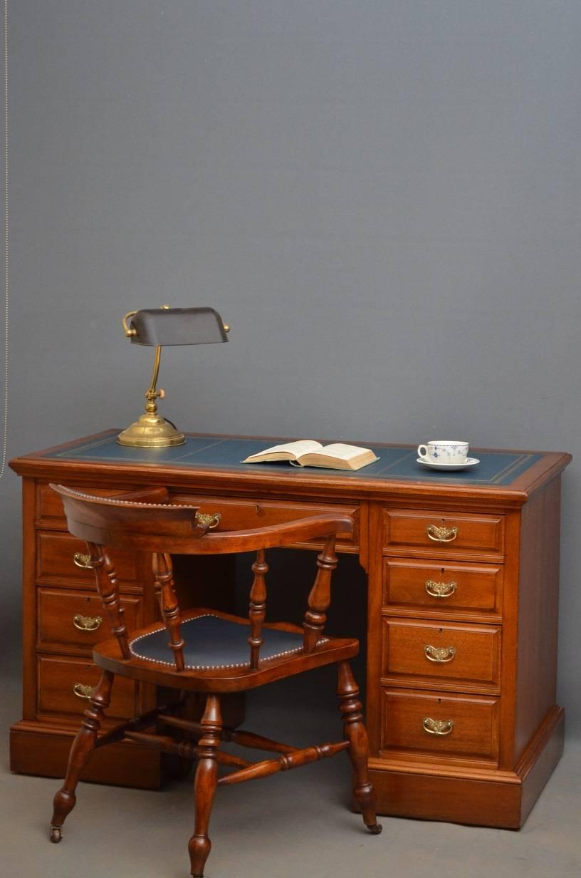 Sn051 Victorian, pedestal desk in mahogany, having blue leather top above frieze drawer flanked by two pedestal with four fielded and graduated drawers each, all fitted with original brass handles, standing on plinth base and castors. All in