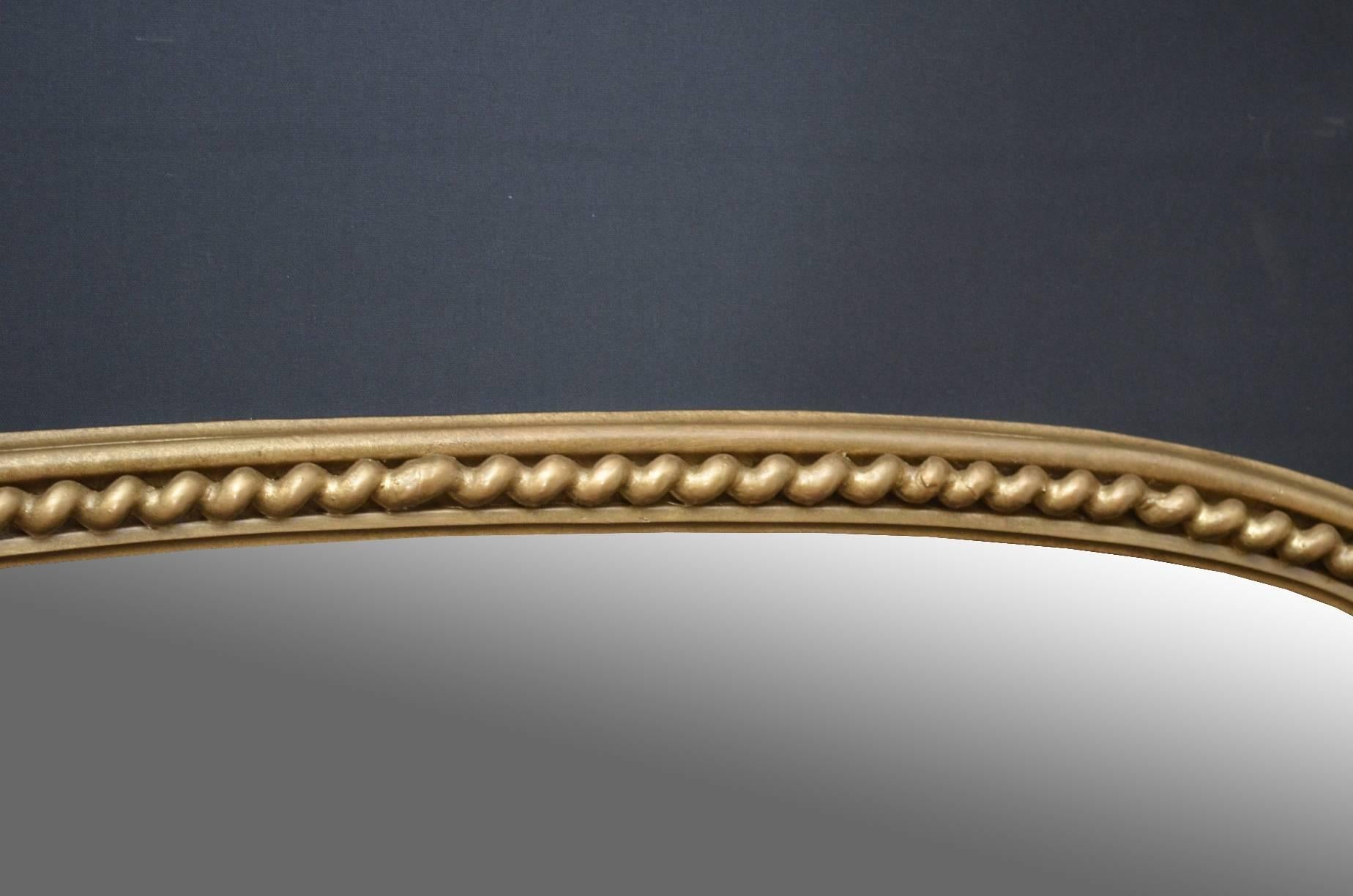 K0103, Excellent English, Victorian gilt mirror, having arched mirror plate in moulded frame with twisted rope decoration and fine scroll carvings to sides. This Victorian over mantle wall mirror has been refinished in the past and is in wonderful