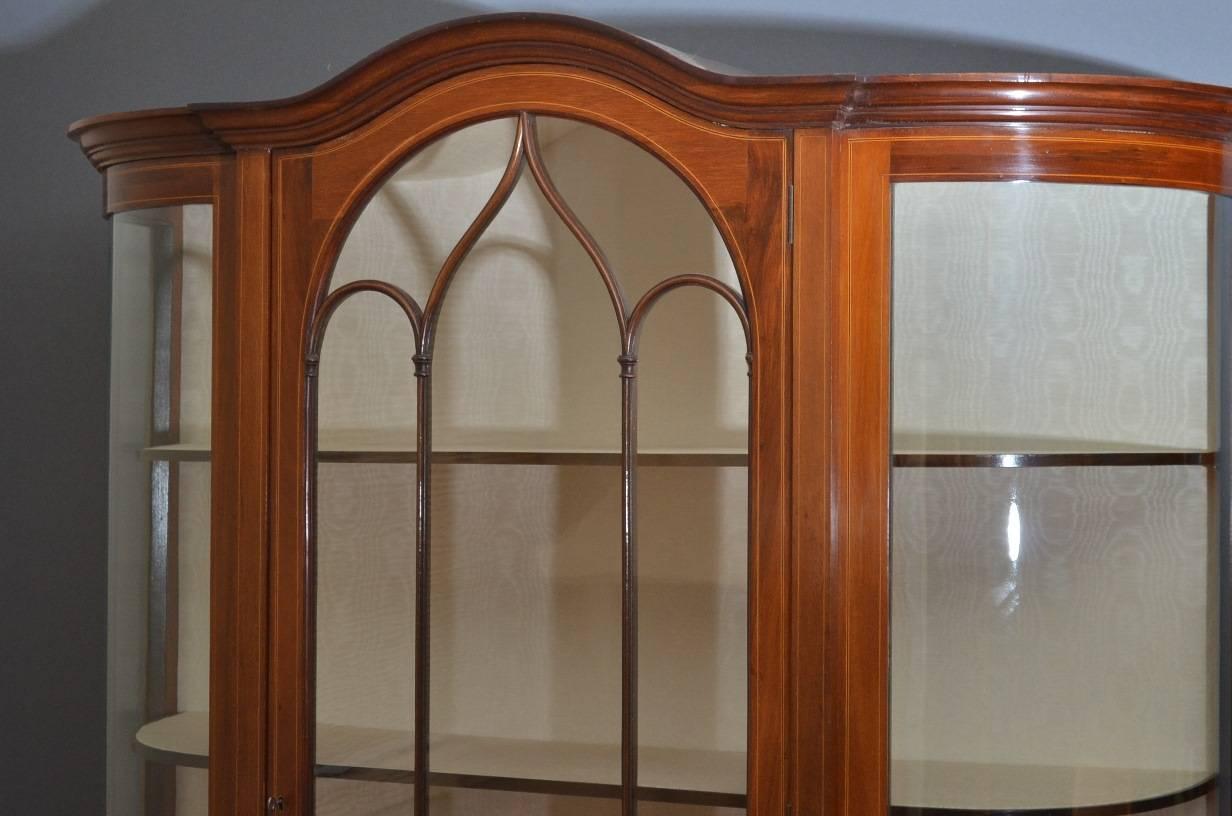 Sn3236, stunning Edwardian mahogany display cabinet-china cabinet, having moulded cornice with astragal glazed, arched door flanked by bowed sides, enclosing three relined shelves all above satinwood string inlaid panels, standing on tapering legs