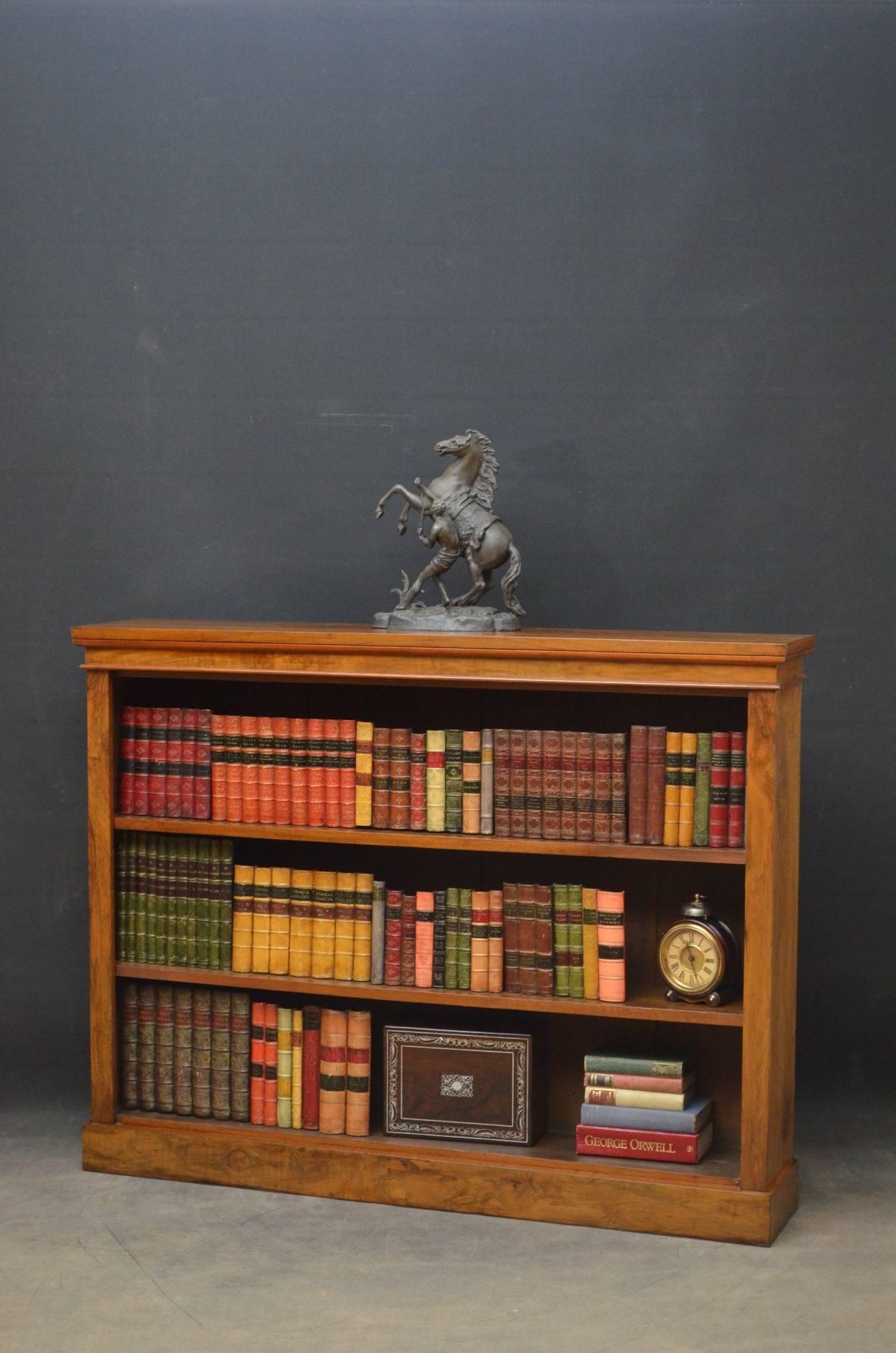 K0184 An attractive Victorian walnut bookcase of elegant design, having figured top above 2 height adjustable shelves flanked by figured pilasters and sides, all standing on plinth base. This Victorian bookcase has been sympathetically restored and