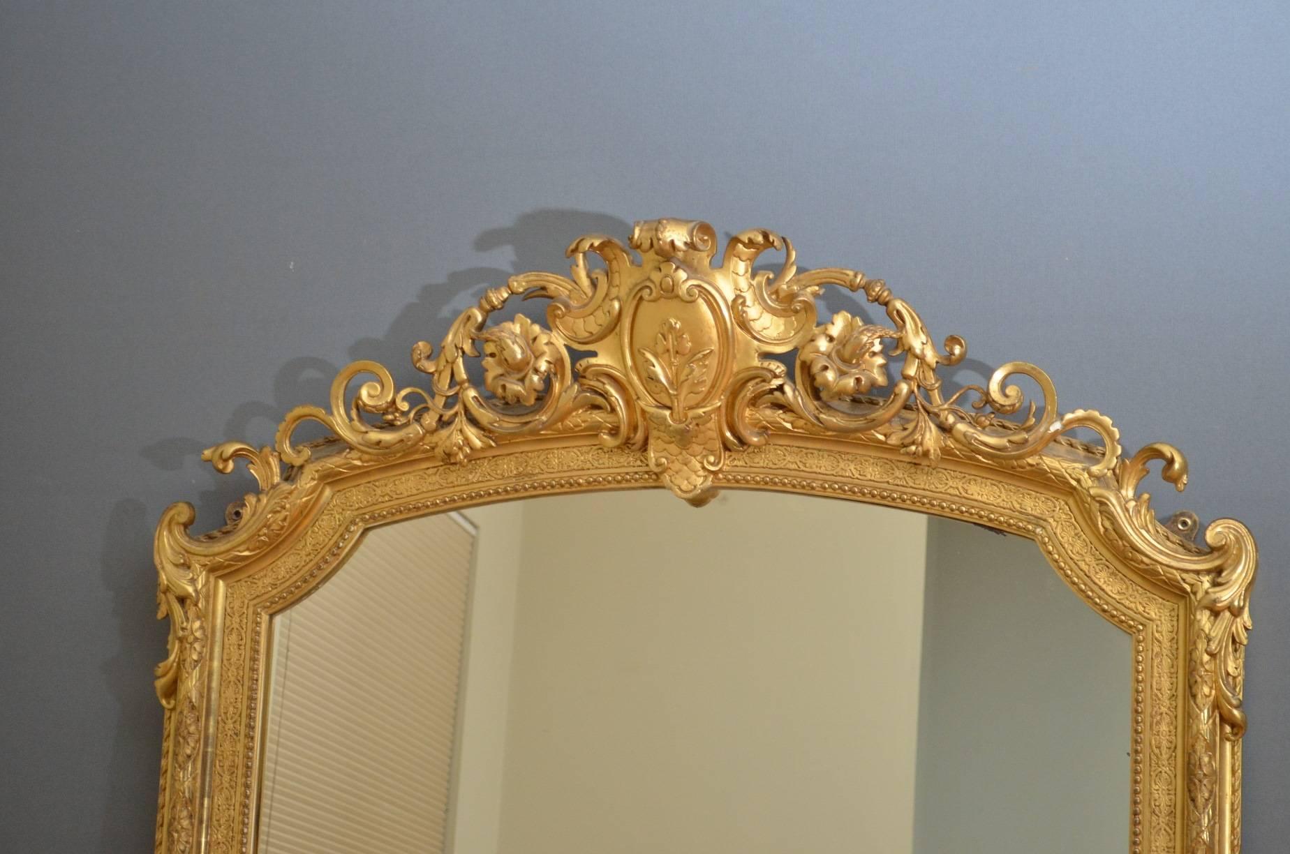 Sn4098, a fine quality and very elegant early Victorian period giltwood mirror of narrow proportions, having shaped mirror plate in finely carved frame. This excellent wall mirror retains original gilt throughout, all in wonderful condition, ready