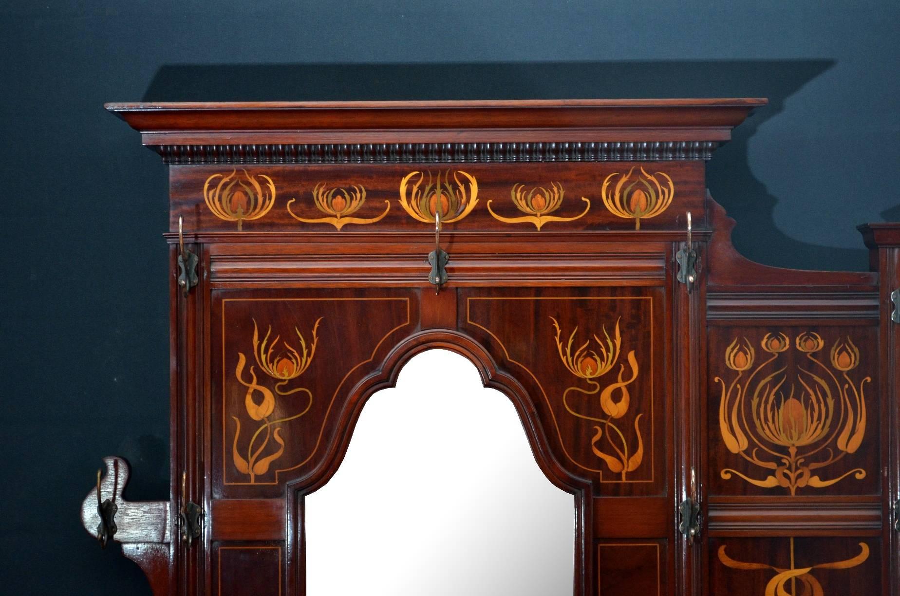 K0228, magnificent Art Nouveau mahogany and inlaid hall Stand by James Shoolbred and Co, having moulded and carved cornice above satinwood inlaid frieze, original bevelled edge mirror and 10 copper plated hooks above small shelf, the base having