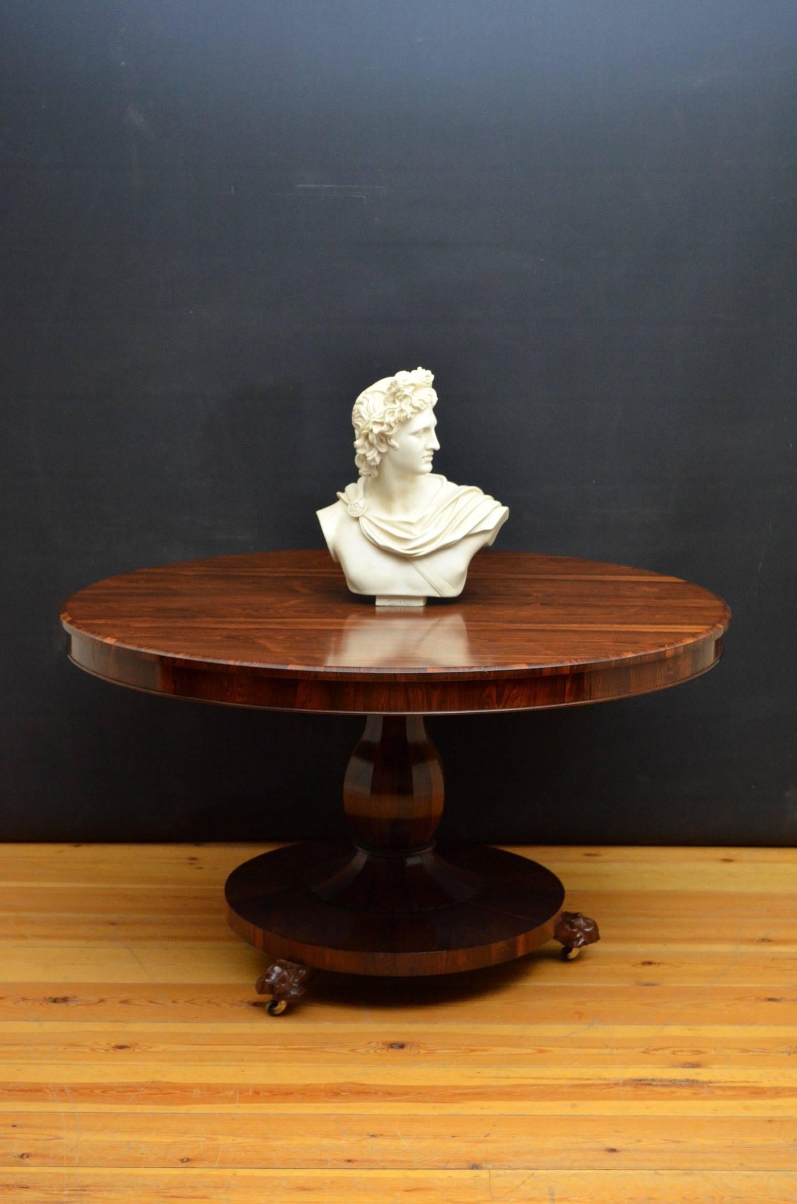 K0112 A fine example of William IV circular, tilt top centre table / loo table in rosewood, having stunning top raised on flat faceted vase shaped column with petal carved collar terminating in circular base, carved paw feet and original castors.