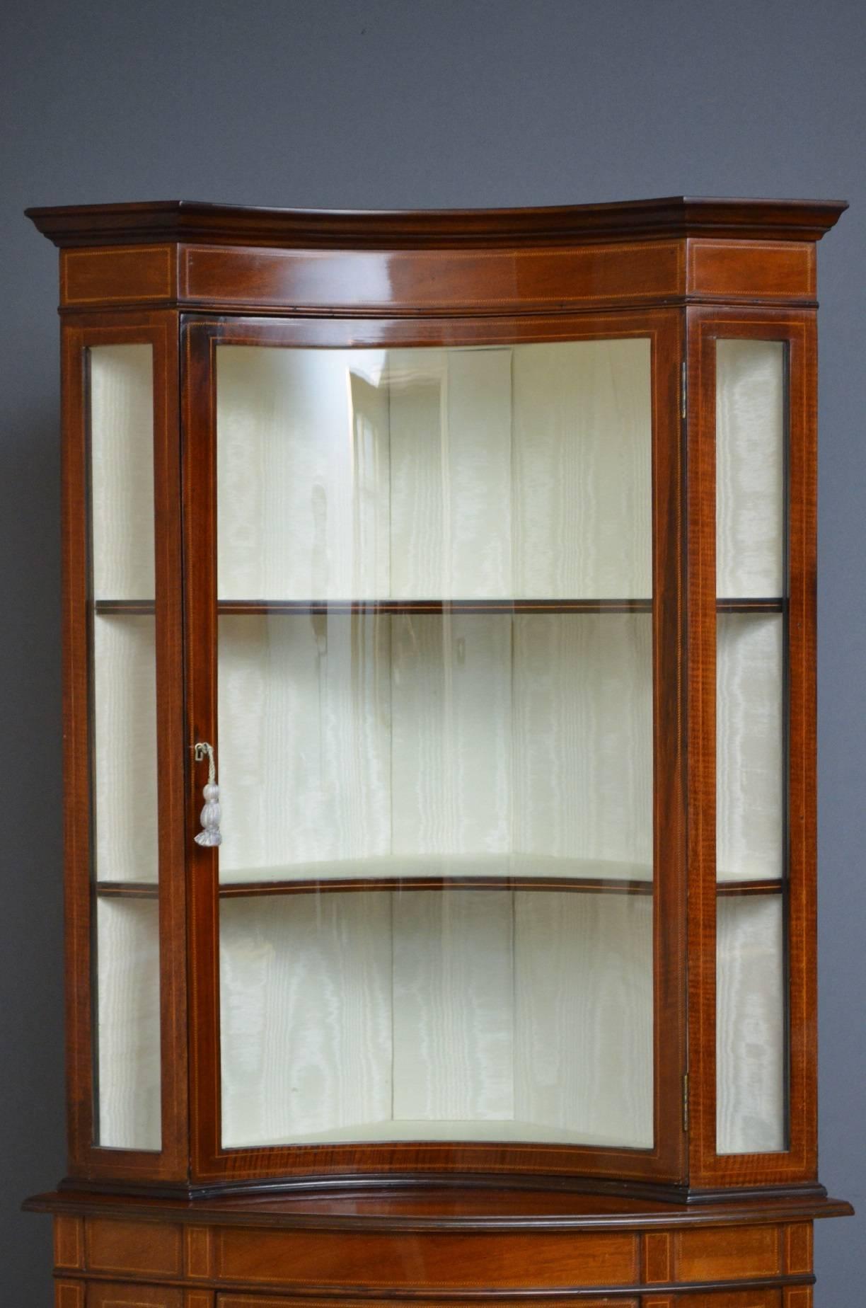 Sn3992, a rare and unusual Edwardian, mahogany, display cabinet or vitrine, having inlaid frieze above concave string inlaid glazed door enclosing two shelves, base having finely inlaid and bowed cupboard door, all raised on slender tapering legs