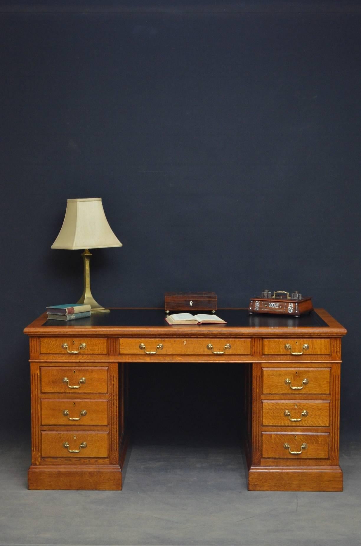 Sn4166 early 20th century oak desk of good proportions being 5 feet wide, having black, tooled leather writing surface above three frieze drawers and three fielded drawers to each pedestal, all fitted with brass swan neck handles and raised on