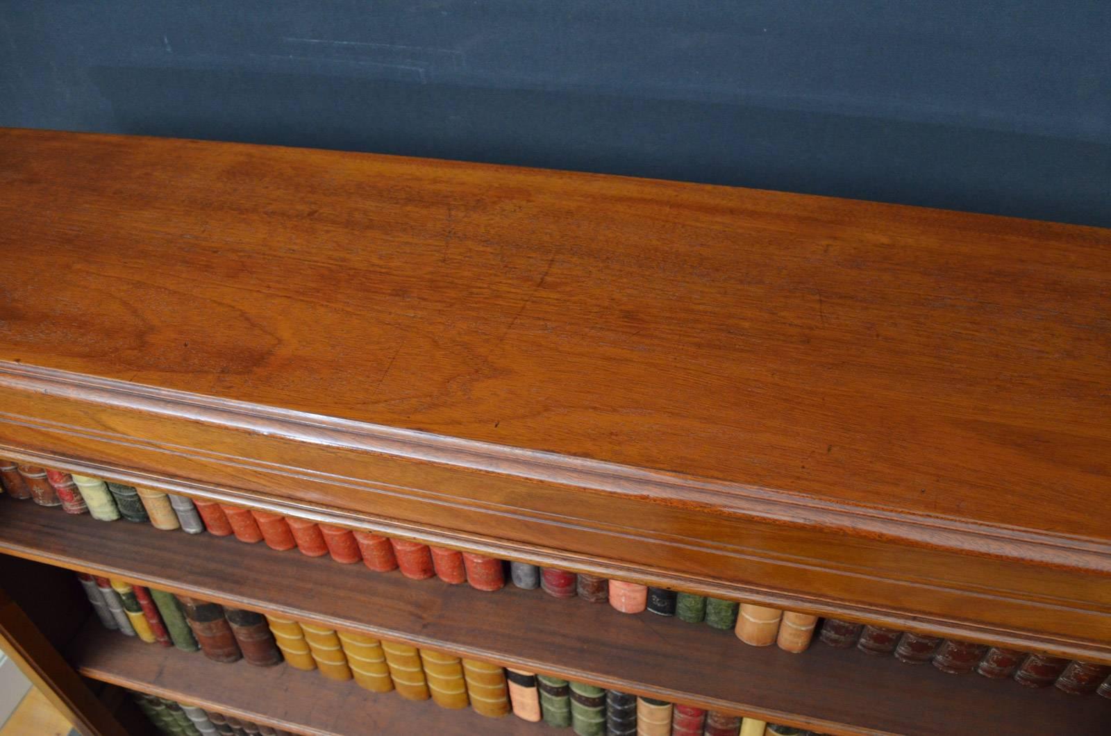 Sn4189 A 19th century, French mahogany bookcase with panelled sides, having figured top with moulded edge and 3 height adjustable shelves above base drawer, all flanked by rounded corners, standing in turned legs. This antique bookcase is in home
