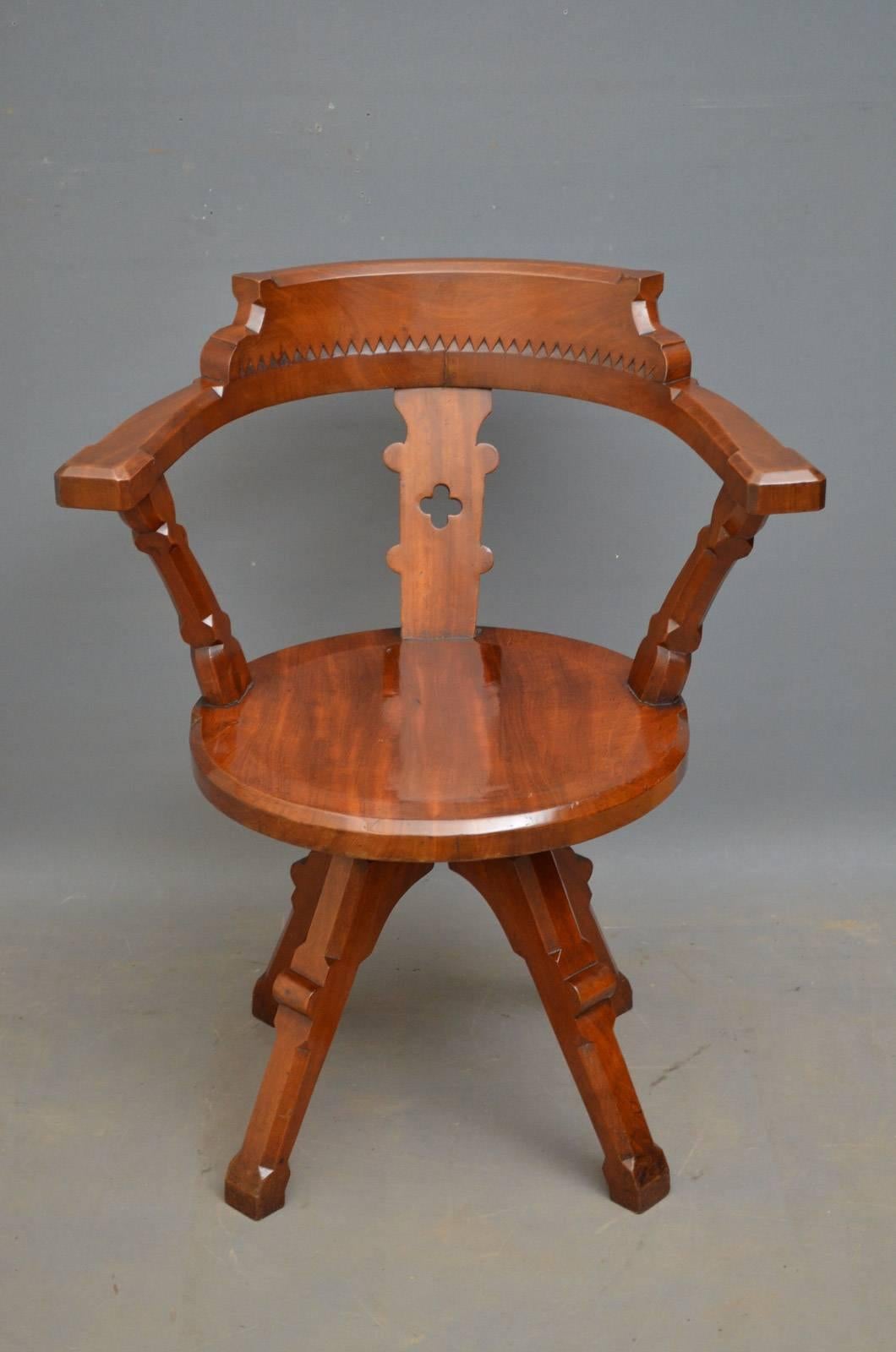 A00 A Victorian, solid mahogany, revolving desk chair with carved top rail above dog tooth decoration, carved centre splat and decorated open arms, all standing on substantial legs. This Gothic Revival desk chair is in wonderful original condition