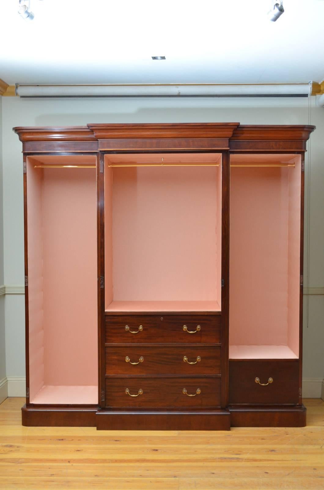 Sn4246 fine quality and very elegant, Victorian three door break fronted wardrobe in mahogany, having moulded cornice above figured mahogany frieze and mirrored centre door enclosing hanging space and a drawer, flanked by arched, panelled cupboard