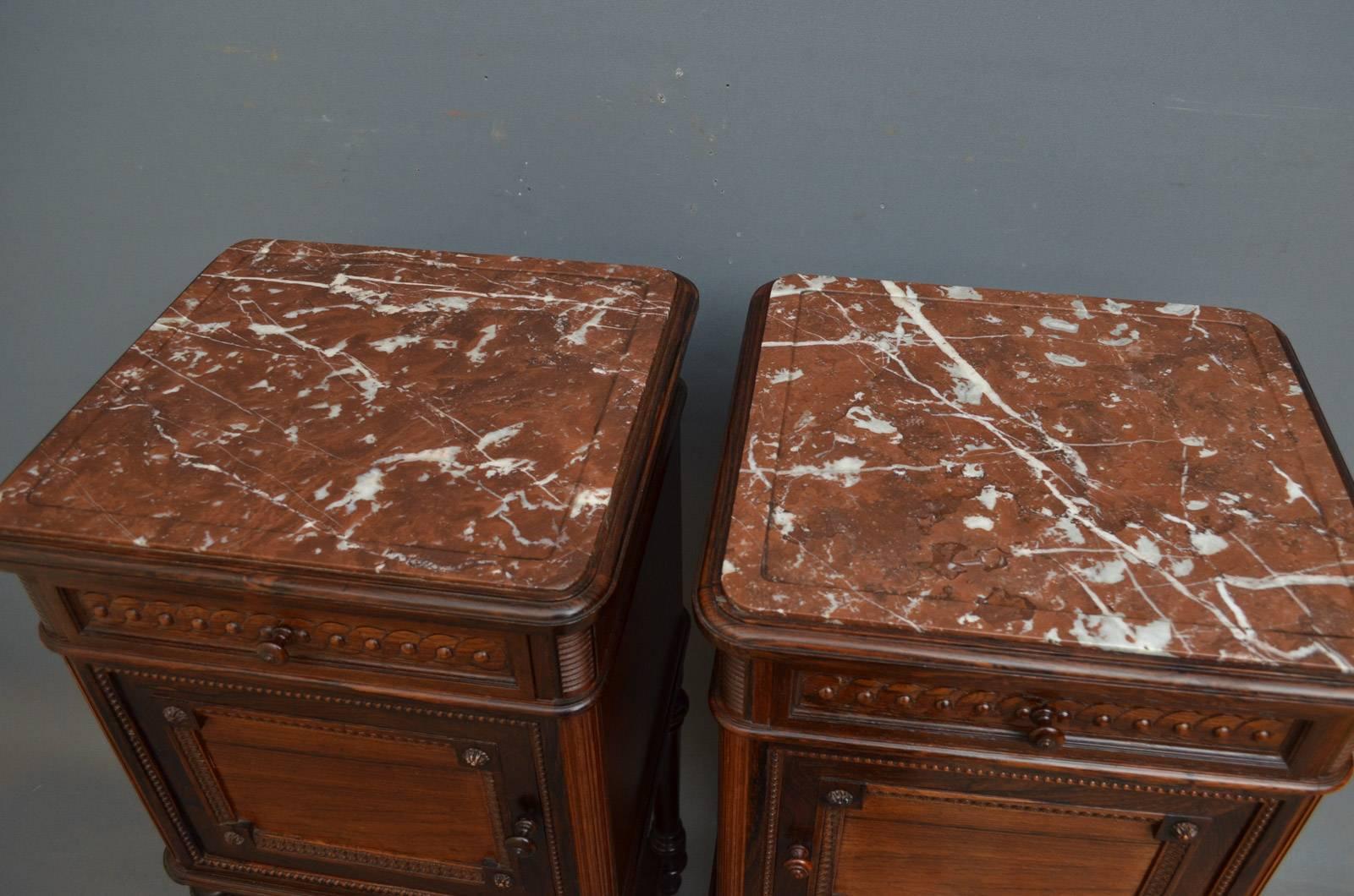 Sn4296, pair of French bedside cabinets in rosewood, each having inset marble top above frieze drawer and cupboard door enclosing original porcelain interior, standing on turned, carved and tapered legs terminating in original castors and united by