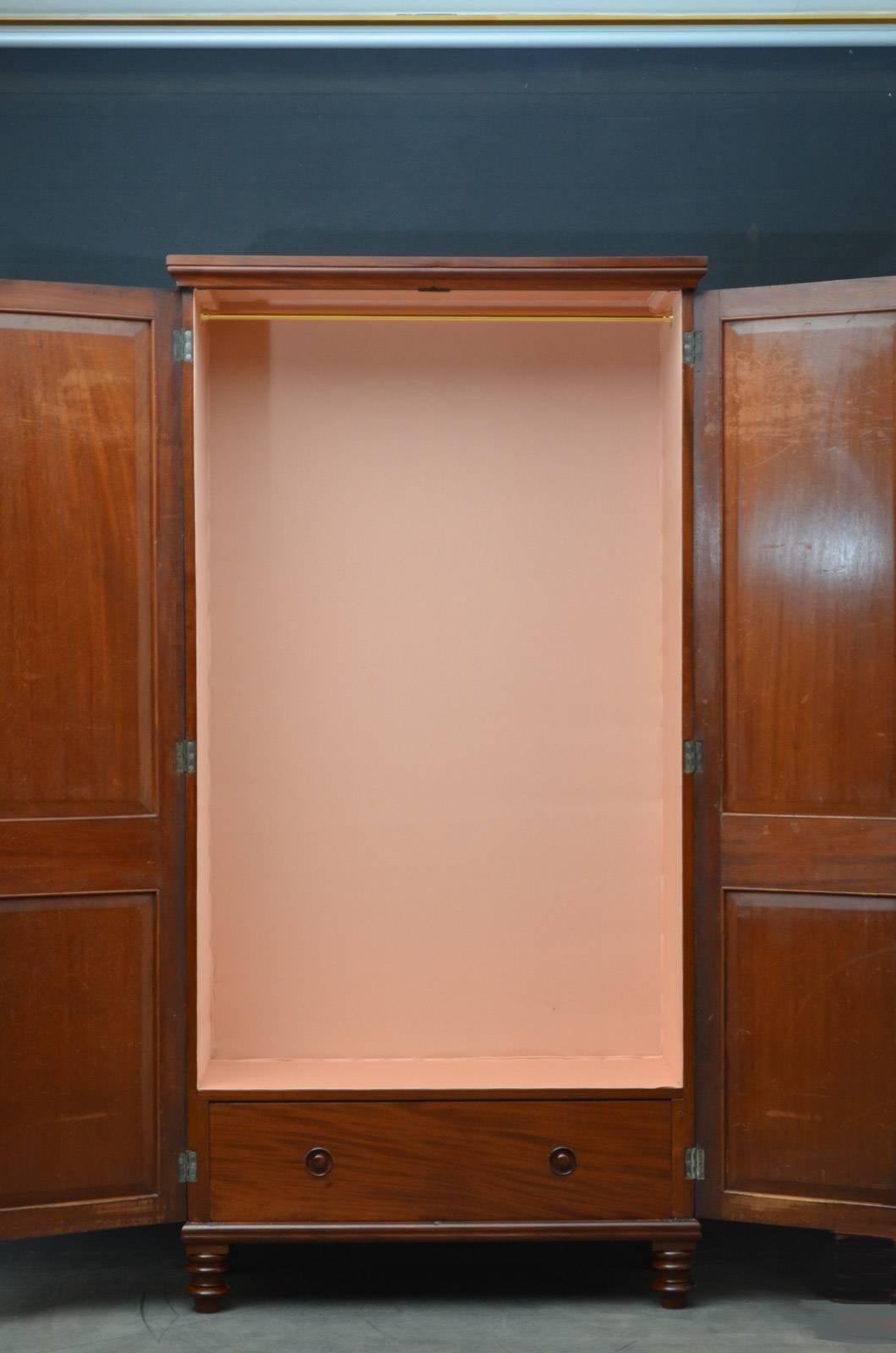Sn4284, slim William IV mahogany wardrobe, having moulded cornice above a a pair of double panelled, figured mahogany doors fitted with original working lock and a key and enclosing relined interior with long hanging section and a drawer, all