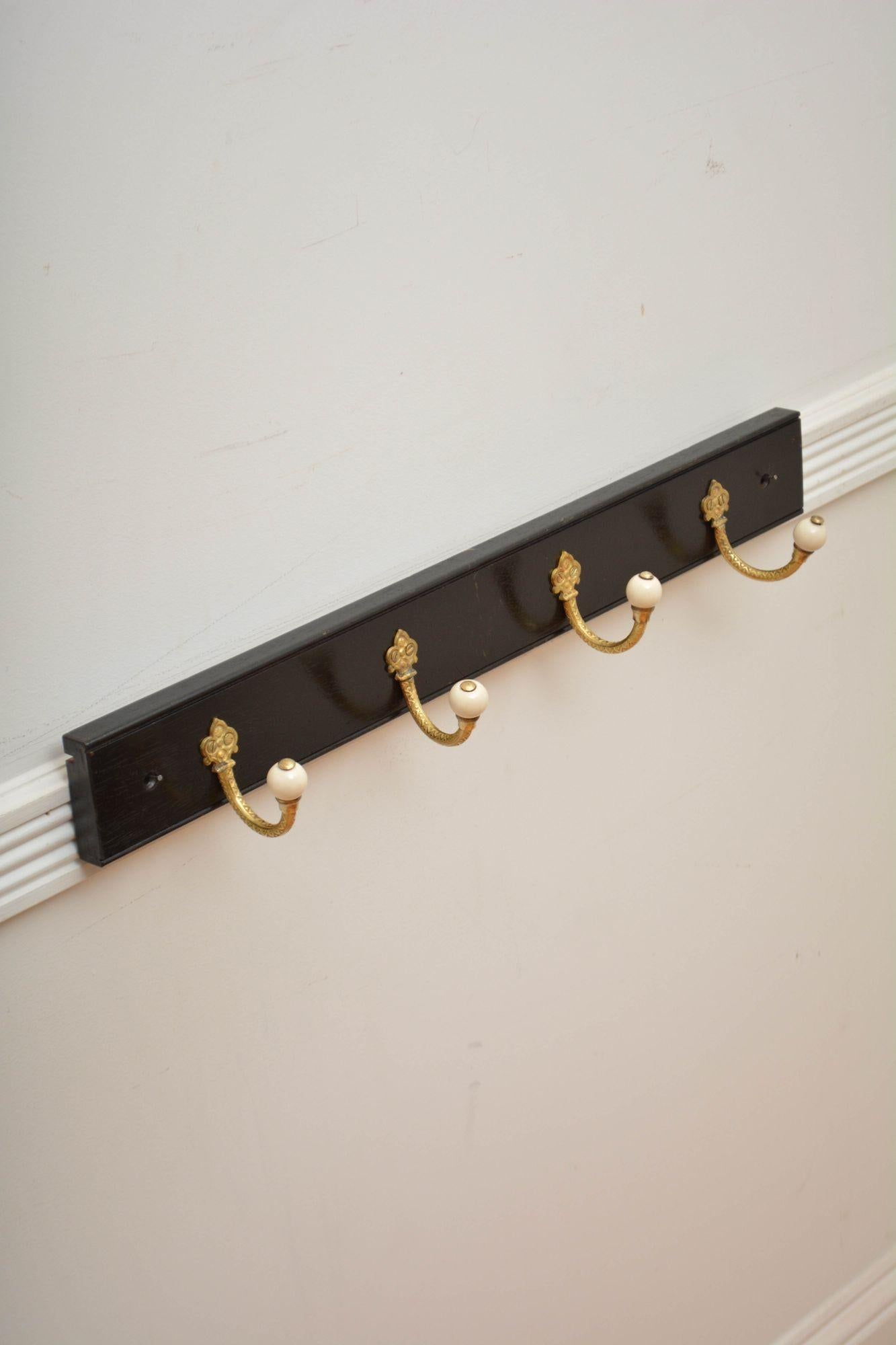 K0312  Set of two brass and ceramic set of four very decorative Victorian coat hooks now on solid mahogany ebonised backing.  Cleaned, polished and ready to place at home. 
H3 1/4