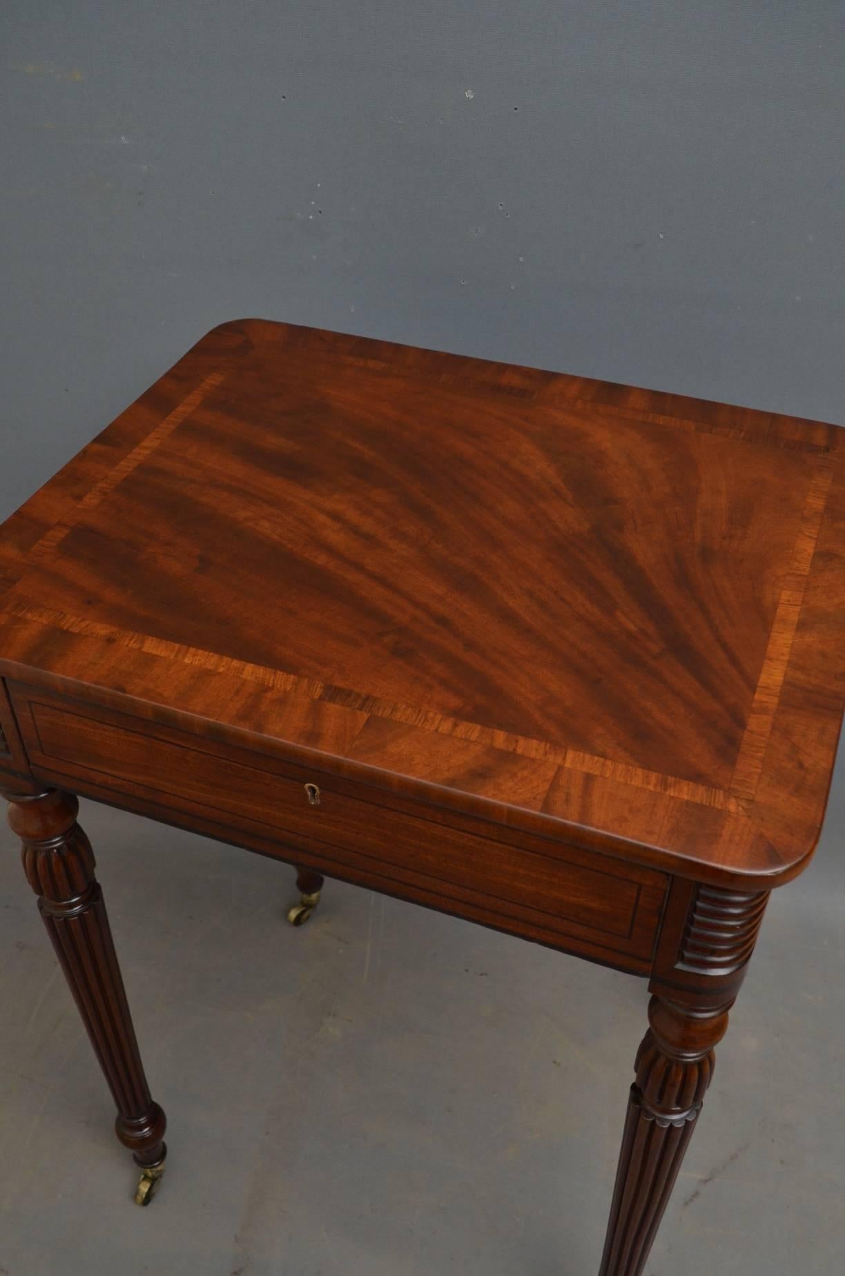 Sn4001. Fine quality Regency side table in mahogany, having figured mahogany, banded top above string inlaid frieze drawer, standing on turned, reeded legs terminating in original brass castors. This elegant table is in excellent home ready