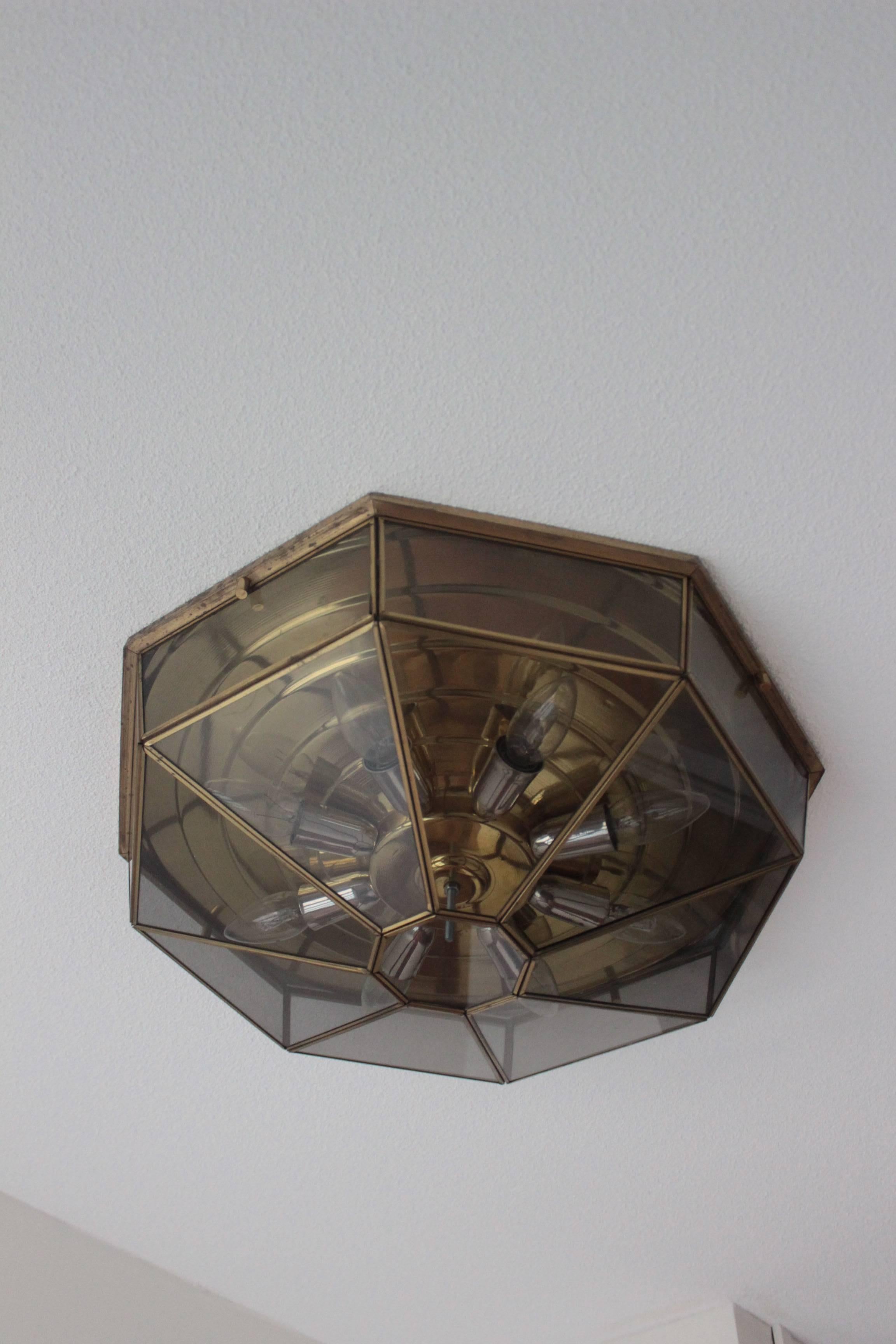 Another nice item for your house!

Two nice ceiling lights by Deknudt Belgium made in the 1970s, this item has eight sides with all the smoked glass in a brass in a separate metal cover connected through each other, the ring under the lamps is also