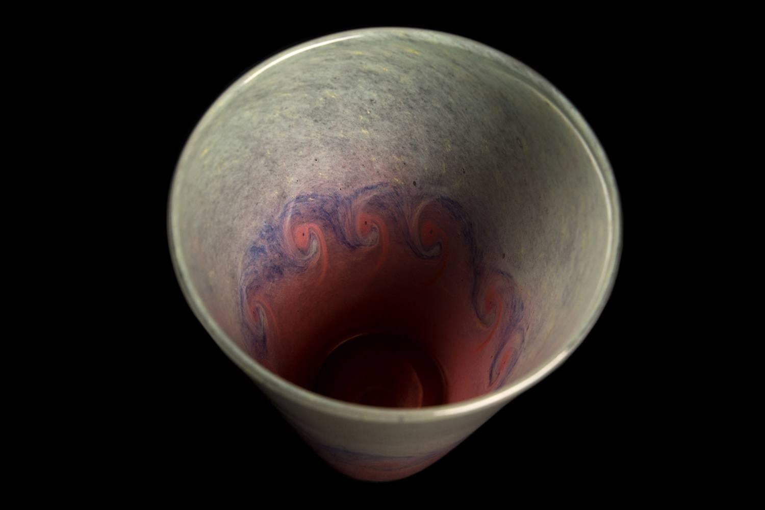 A vivid pale green and pink art glass vase with swirling purple wave pattern Of convenient bucket shape. To the base is the raised button pontil typically found in Vasart. A highly collectable piece. 

Signed Vasart, Scotland.

The Vasart glass