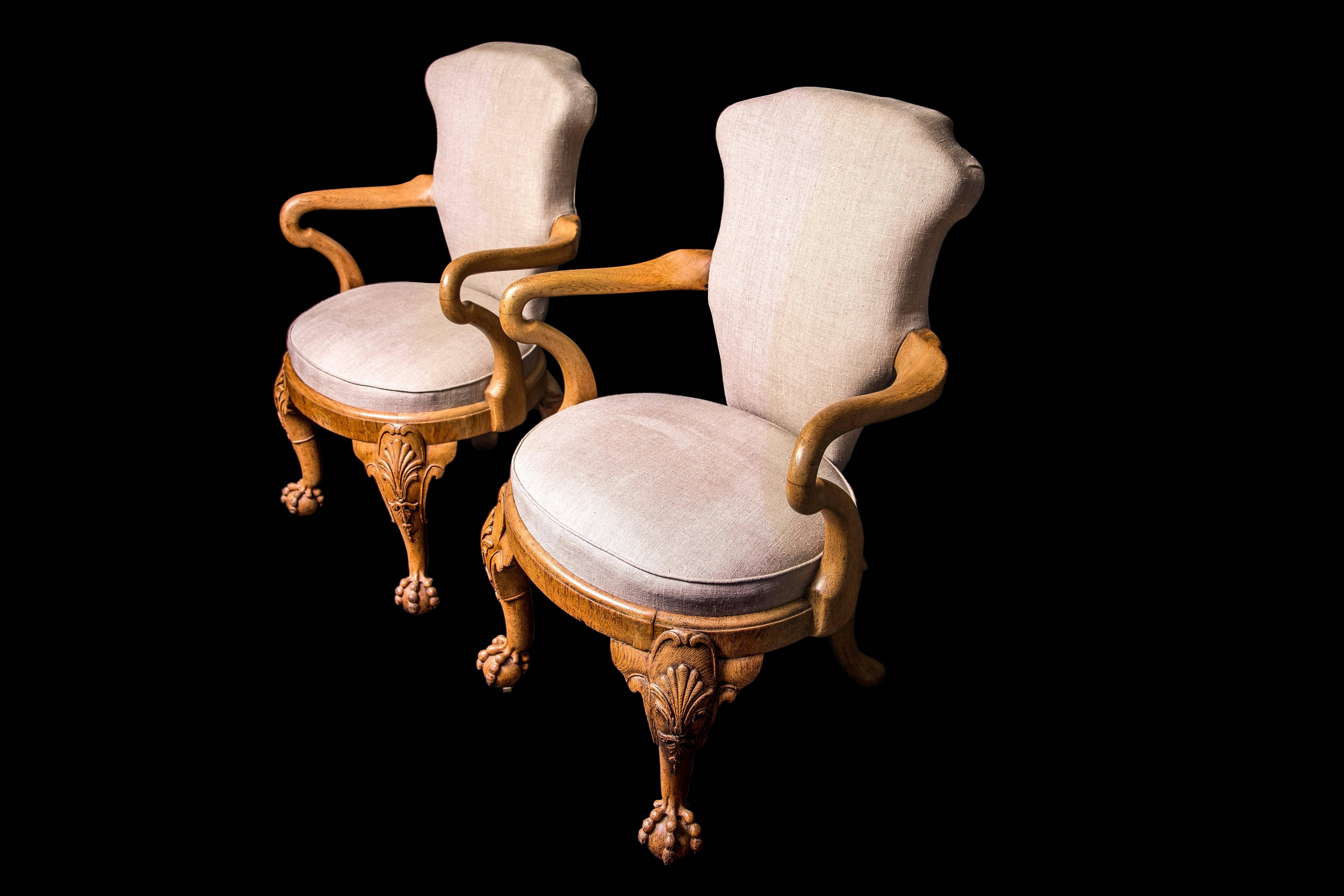In the George II style, circa 1827, each with shepherd's crook arm supports, on scroll, shell and bellflower pendant carved cabriole front legs terminating in claw and ball feet, with splayed back legs, on recessed brass castors, one chair stamped: