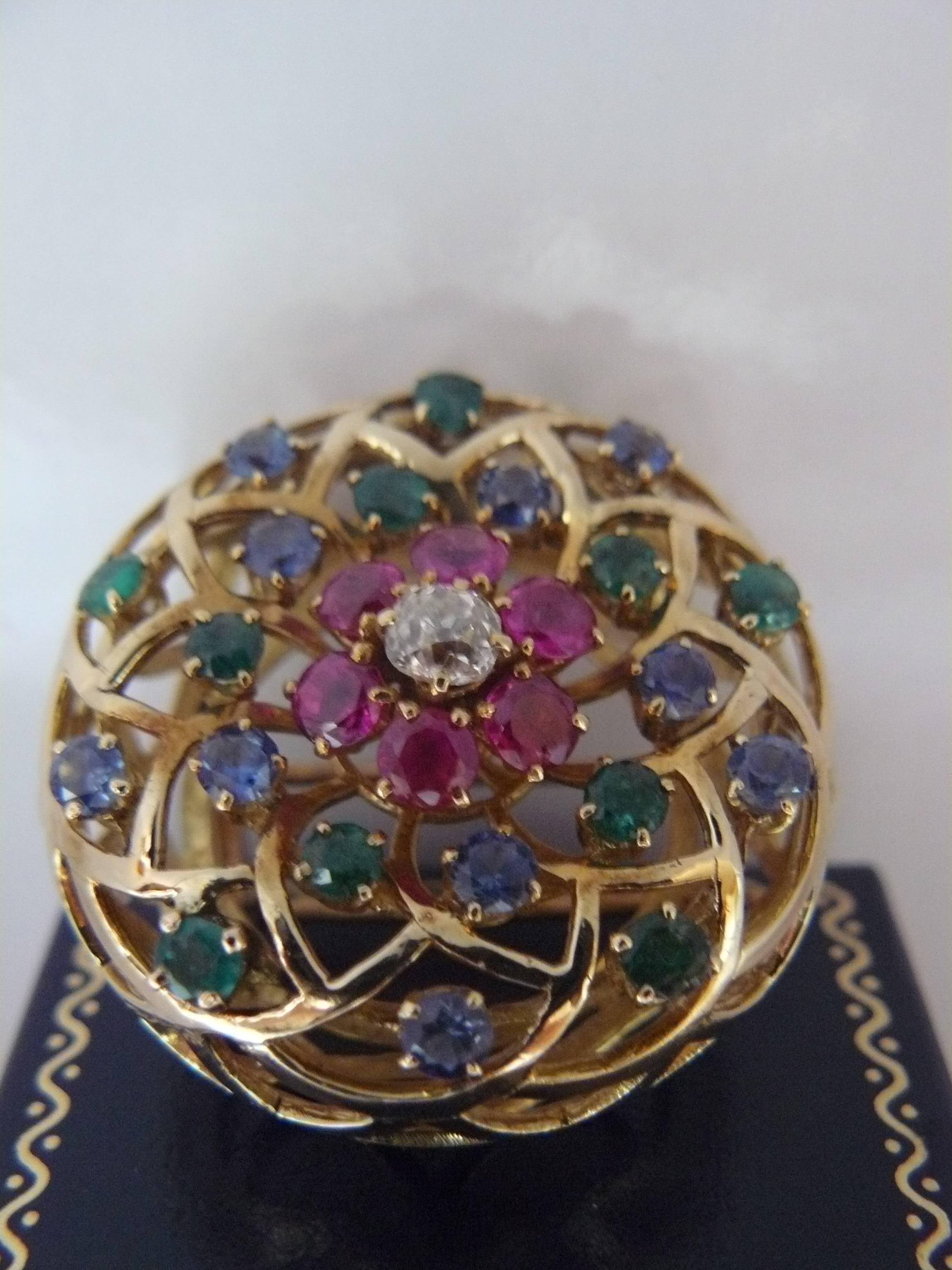 An 18-karat yellow gold brooch, circa 1970s(in the style of Mellerio) set with approximately:10 sapphires:1.50cts;10 emeralds:1ct;6 ruby:1.80cts and 1 diamond old cut:0.50ct.
French control mark. 
Weight:25.19grs.
 
 


