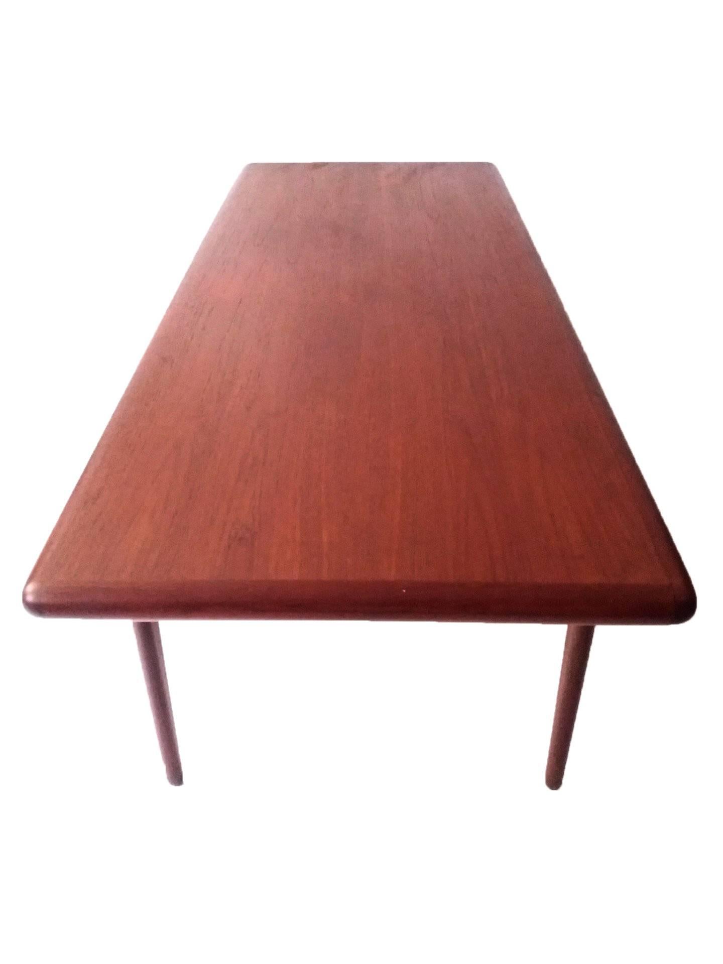 This rare Mid-Century Modern coffee table in teak is designed by Niels O. Møller in Denmark. It has elegant slender, tapered legs and a dark edge encompassing the table.