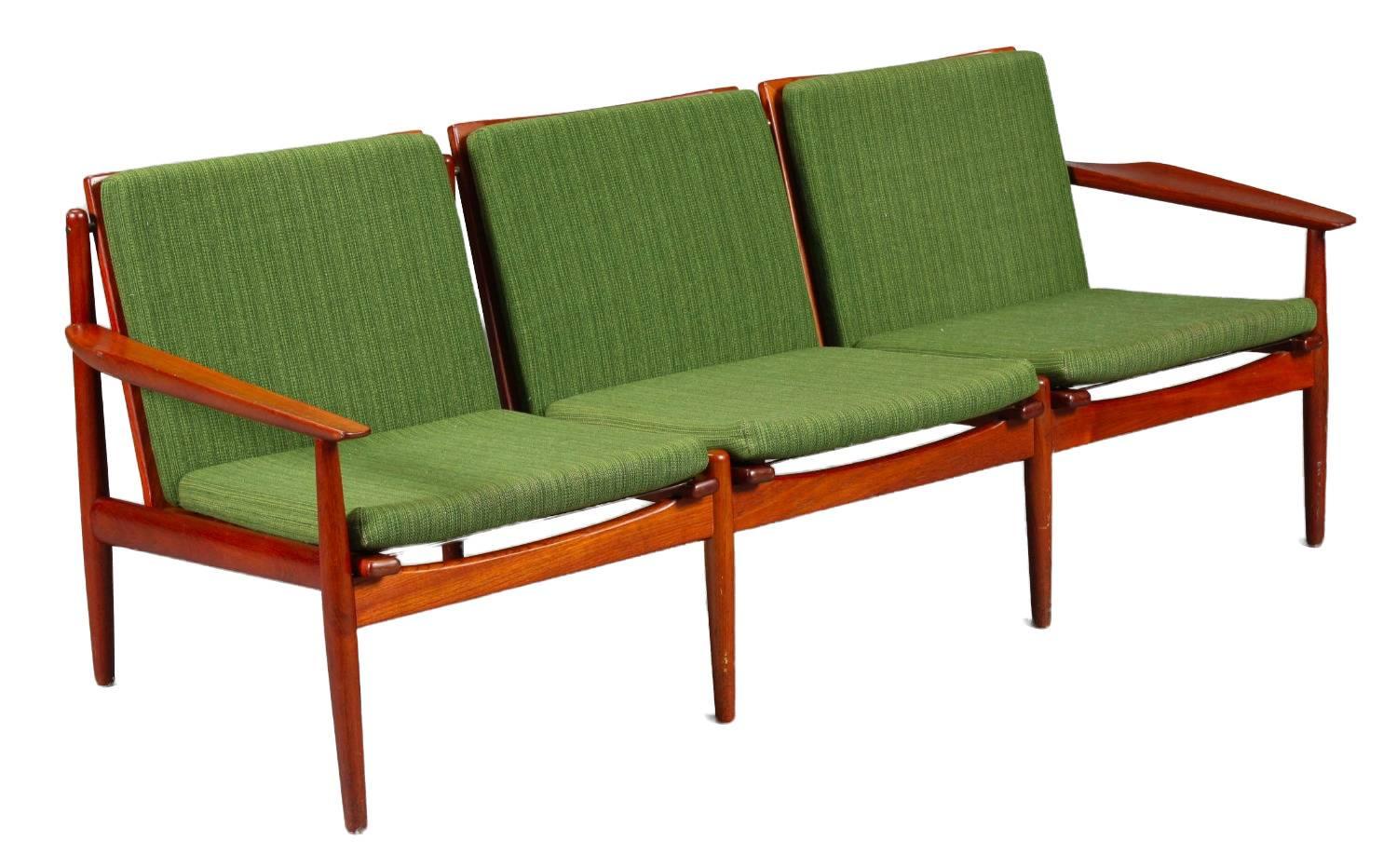 Danish Mid-Century Modern three person couch with green cushions upholstered in wool.

It features a teak frame with a slatted back and turned legs.

It is designed by Arne Vodder in the 1960s and produced at Glostrup Møbelfabrik.

Length: 188
