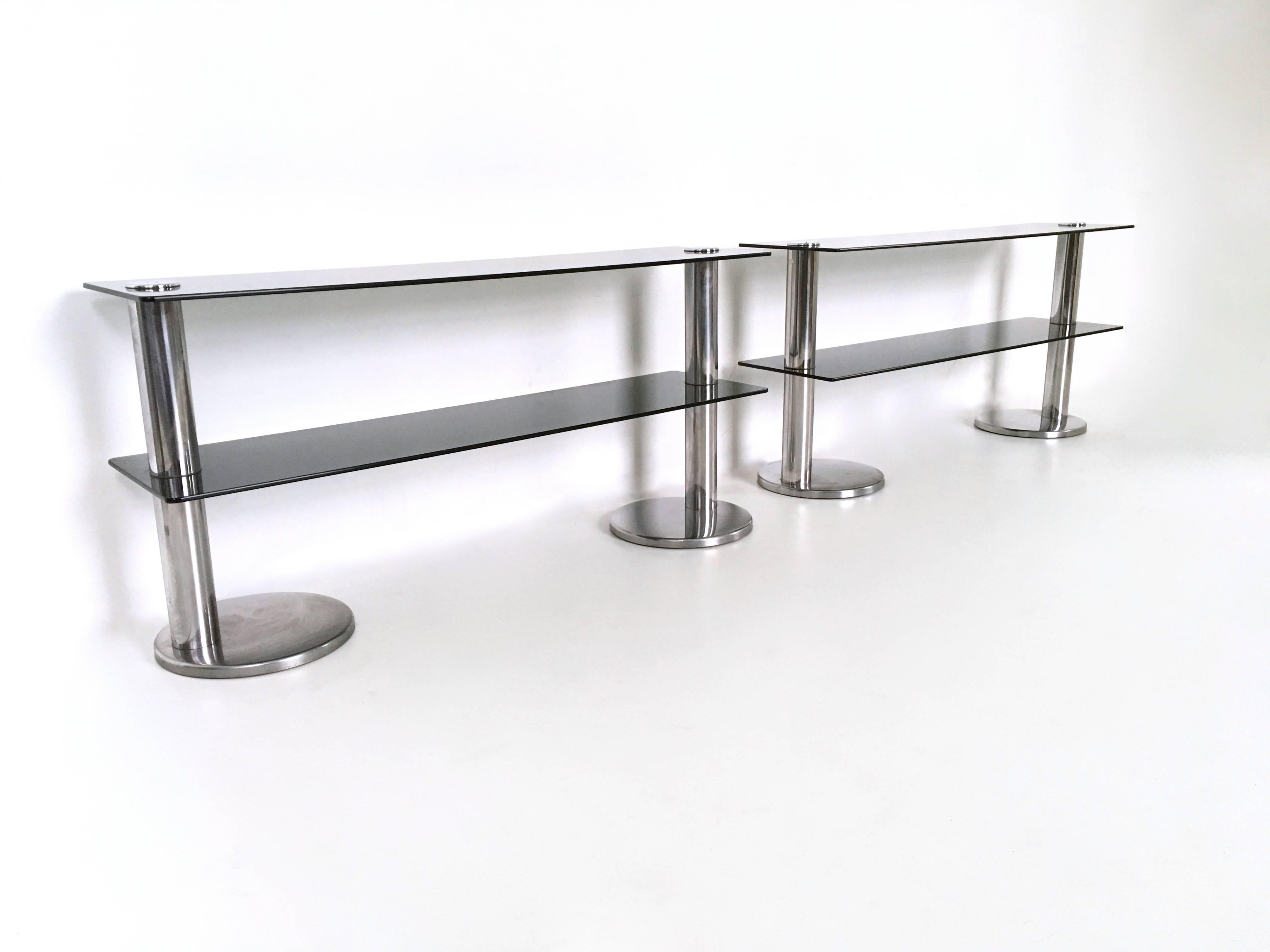 They feature a chromed metal frame and two glass shelves each.
They are vintage, therefore they might show slight traces of use but they can be considered as in very good original condition.

Measures: Width 150 cm
Depth 38 cm
Height 73 cm.