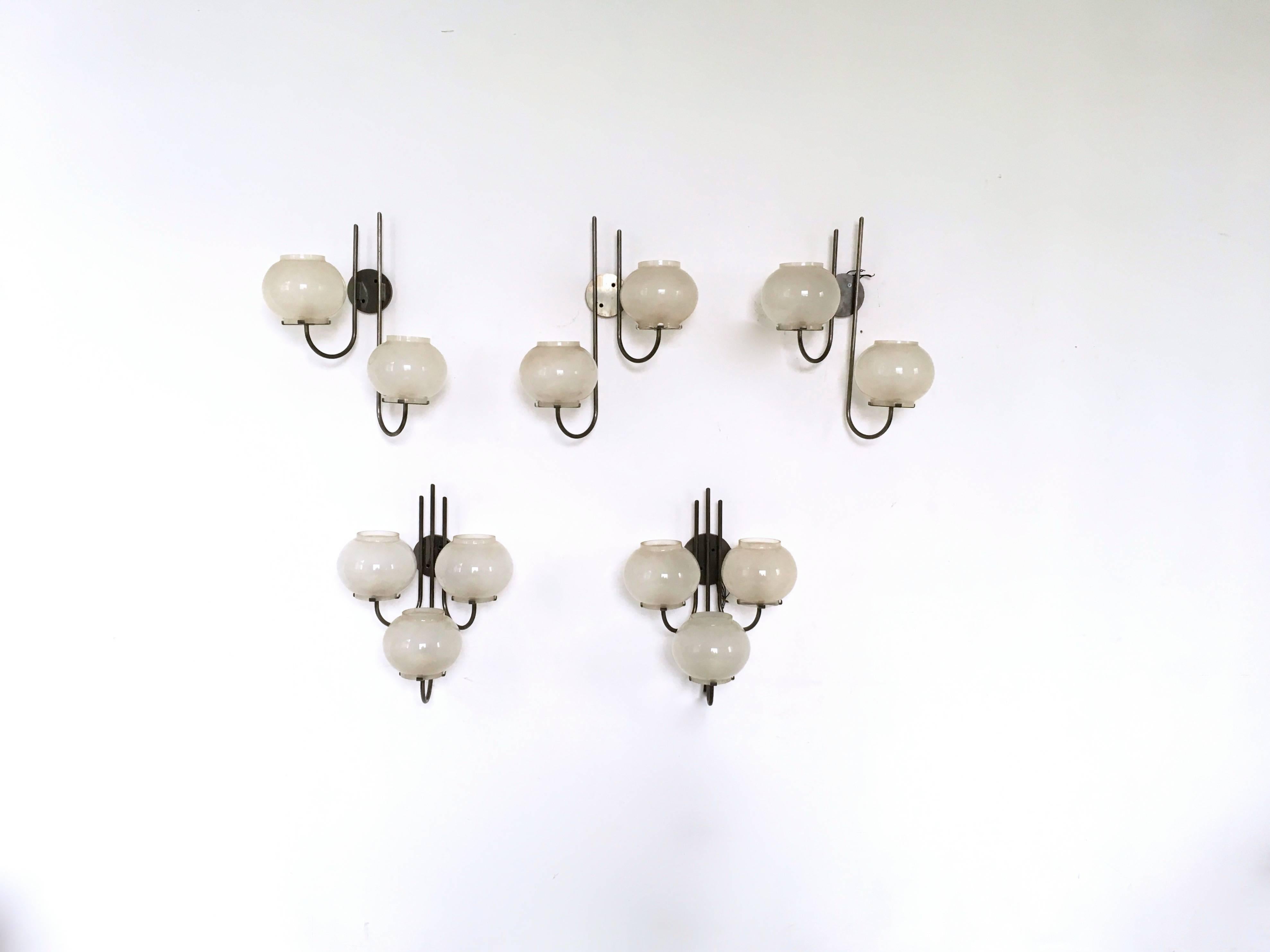 This is a pair of nickel-plated brass and frosted glass sconces designed in the style of Gino Sarfatti for Arteluce in the 1960s.
They may show slight traces of use since they are vintage, but they can be considered as in very good original