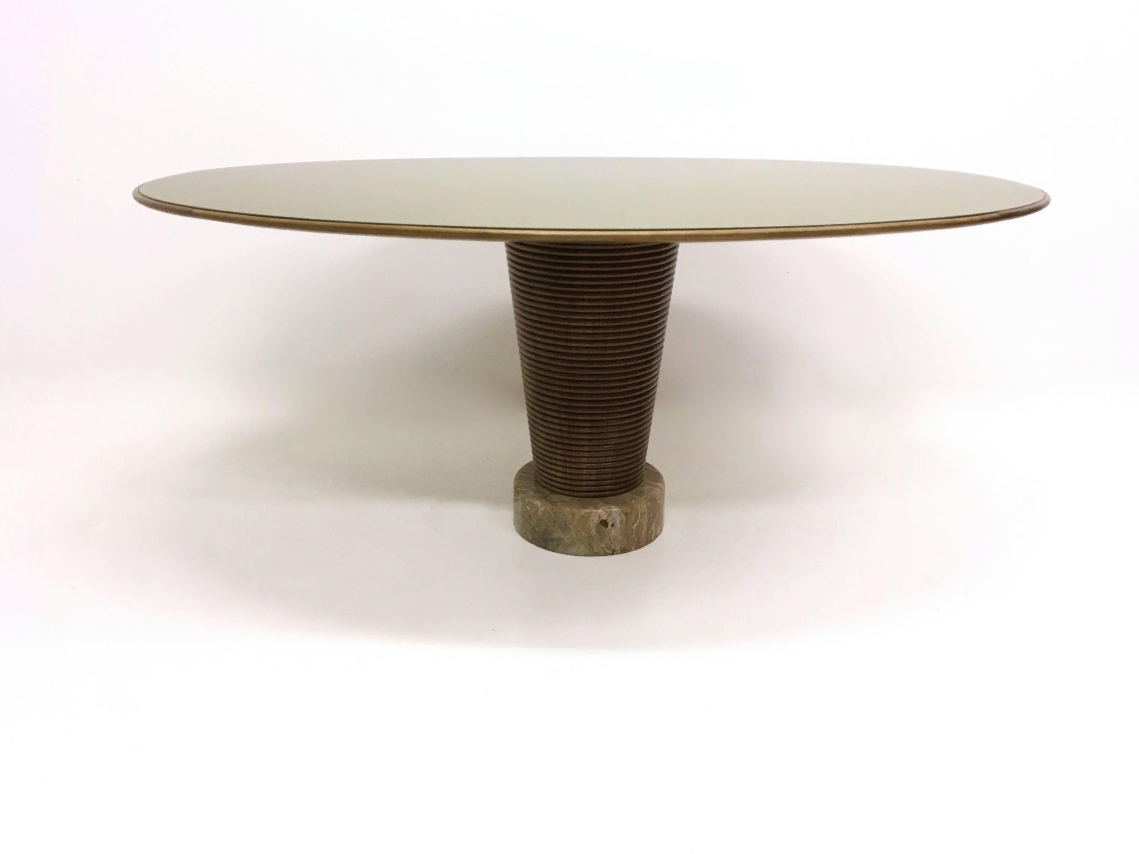 This table has a large central leg made from solid turned walnut.
It also has a marble pedestal and a wood top with a back-painted glass on it.
   