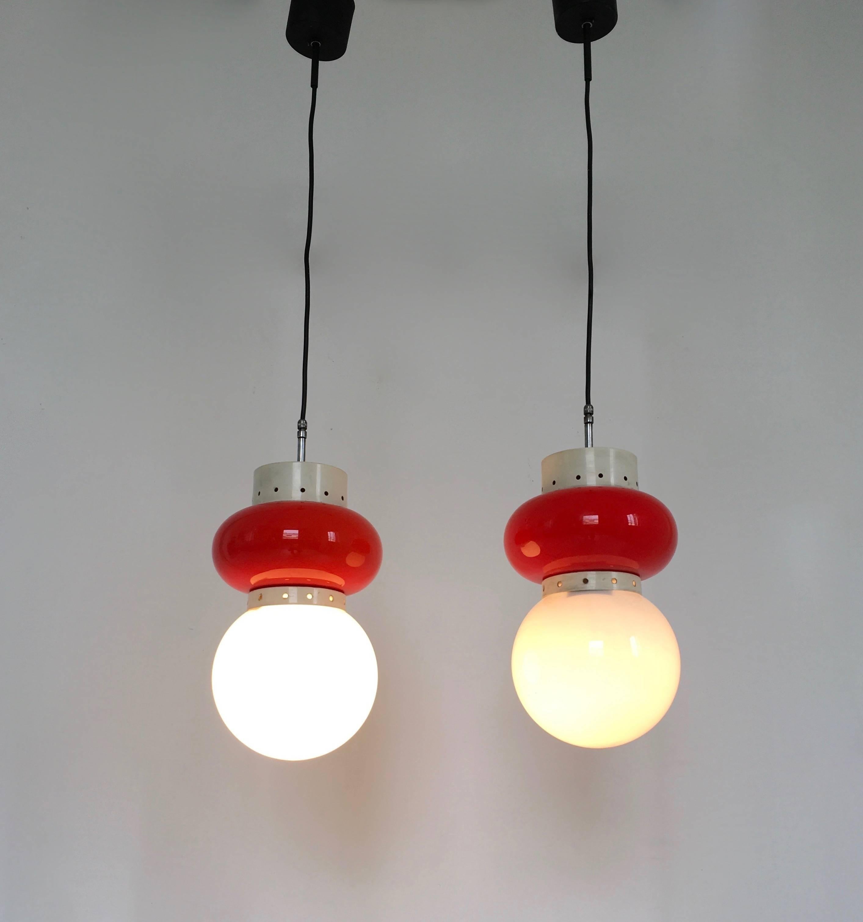 Italy, 1960s. 
These pendants feature blown and cased glass shades and varnished metal elements. 
Their height is adjustable.
They are vintage, therefore they might show slight traces of use, but they can be considered as in perfect original