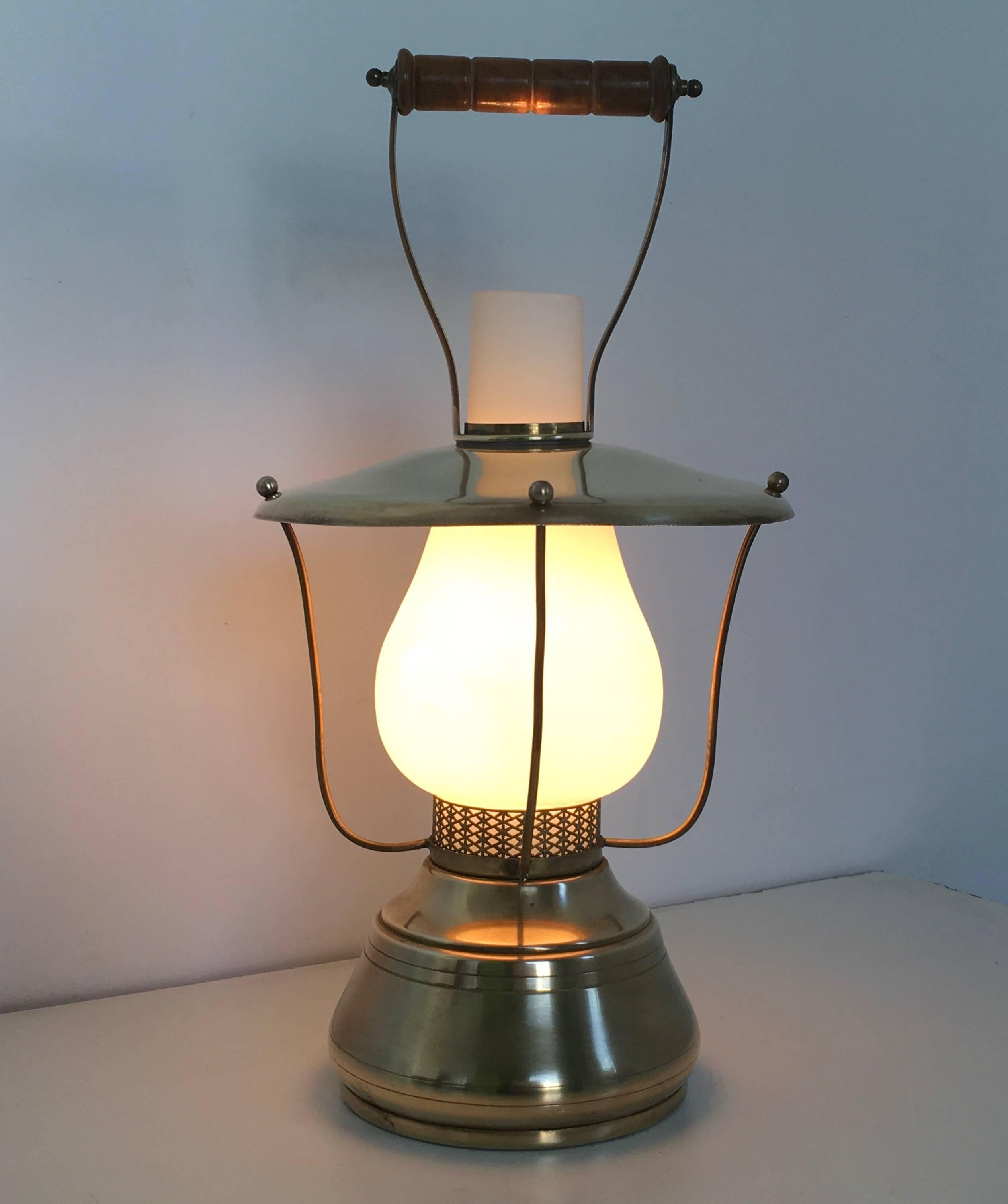 Made in Italy, 1950.
This lantern is made in brass, white encased glass and features a turned wood handle. 
It is a vintage piece, therefore it might show slight traces of use, but it can be considered as in perfect condition and ready to give