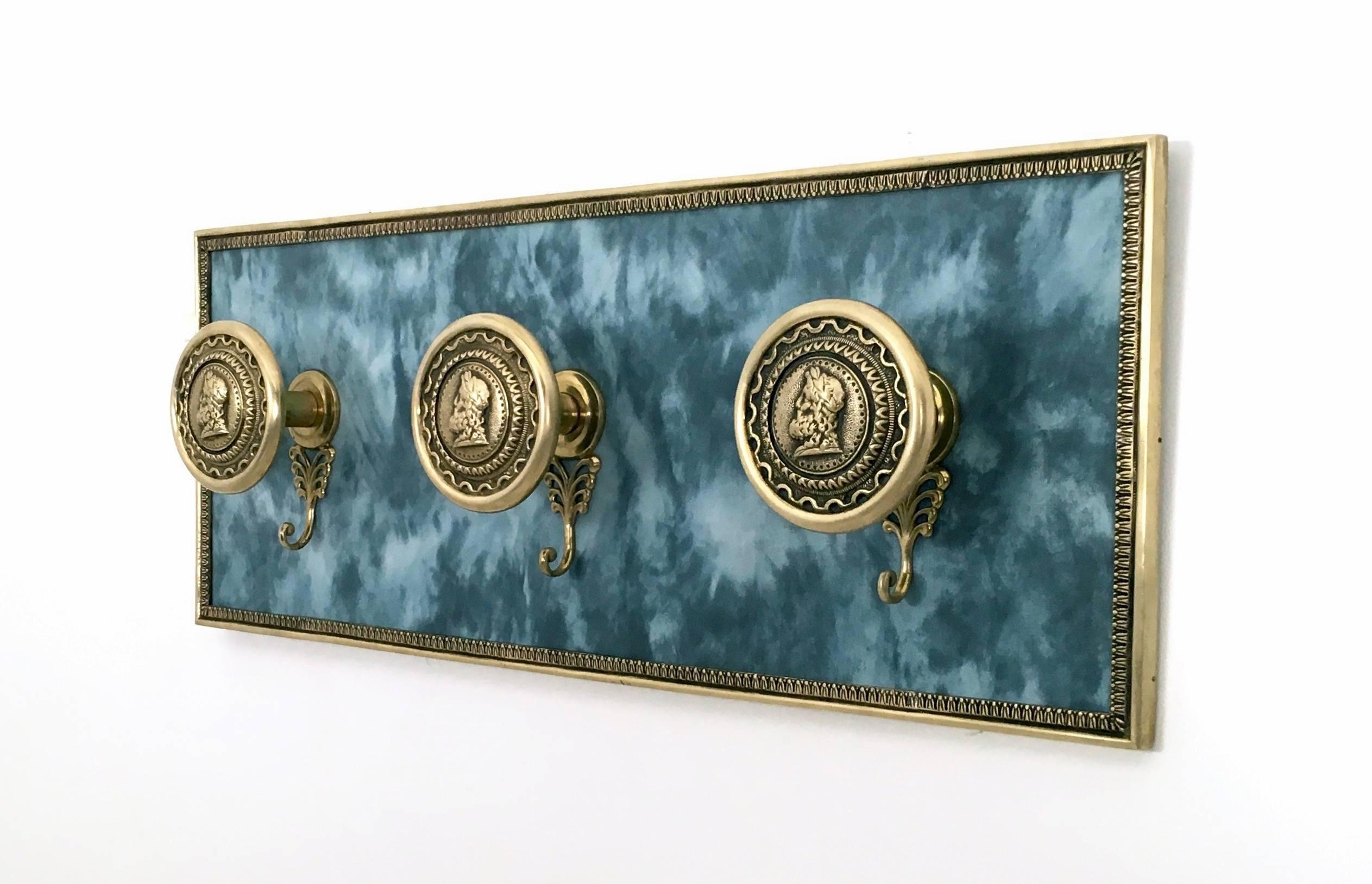 This wall-mounted coat hook is made in wood, brass and fabric. 
It is a vintage piece, therefore it might show slight traces of use, but it can be considered as in very good original condition.

Measures: width: 74 cm
Depth: 12 cm
Height: 29 cm.