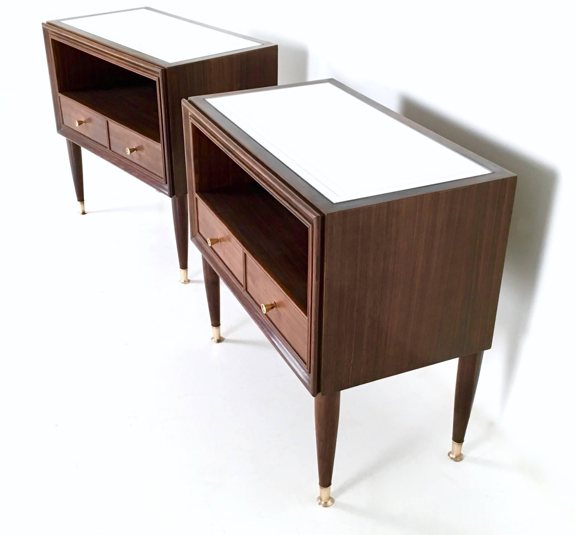 These two high-quality nightstands are made in mahogany and feature a mirror top and brass handles and feet caps. 
In perfect original condition and they don't need to be restored. 
They were part of 