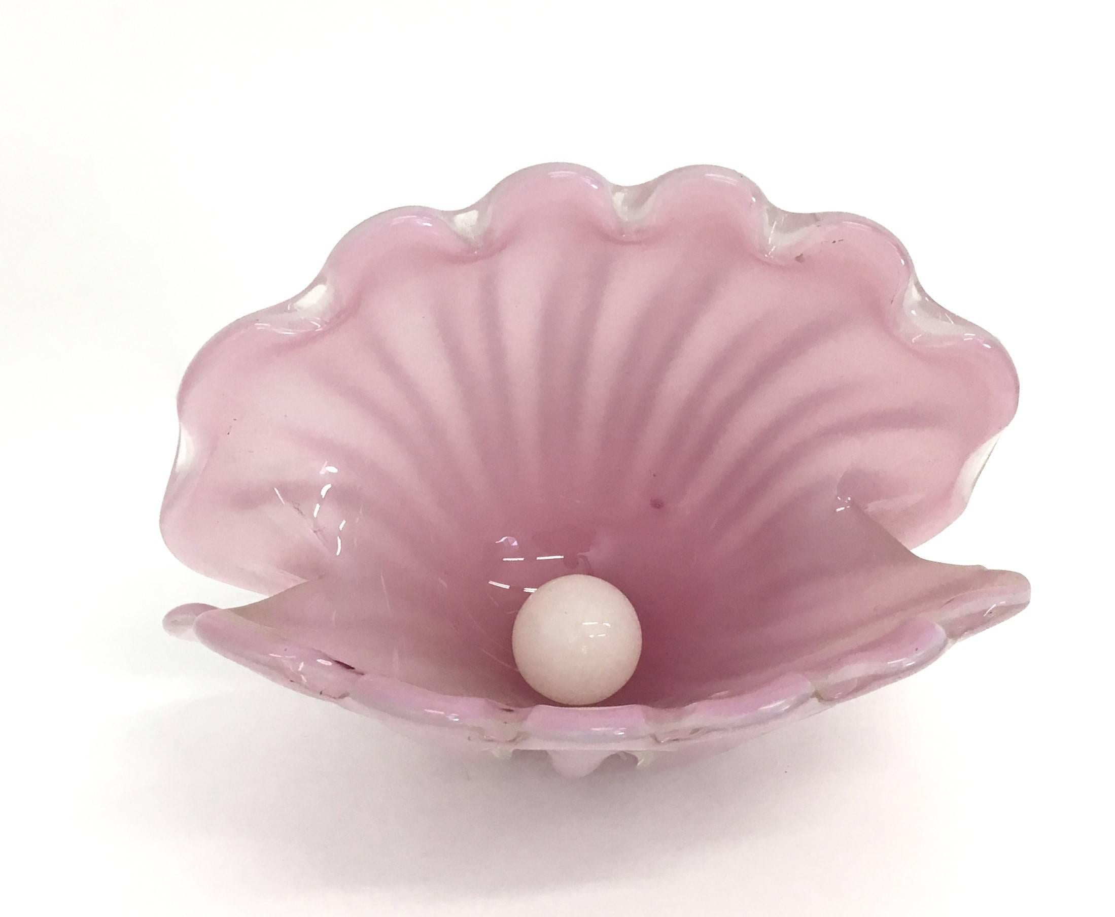 This large shell bowl is made from pink opaline glass under 'lattimo' glass opalescent ribs, with a scalloped rim, folded ends, and two polished bases, so the shell can rest straight or tilted.
In very good condition and ready to become a piece in a