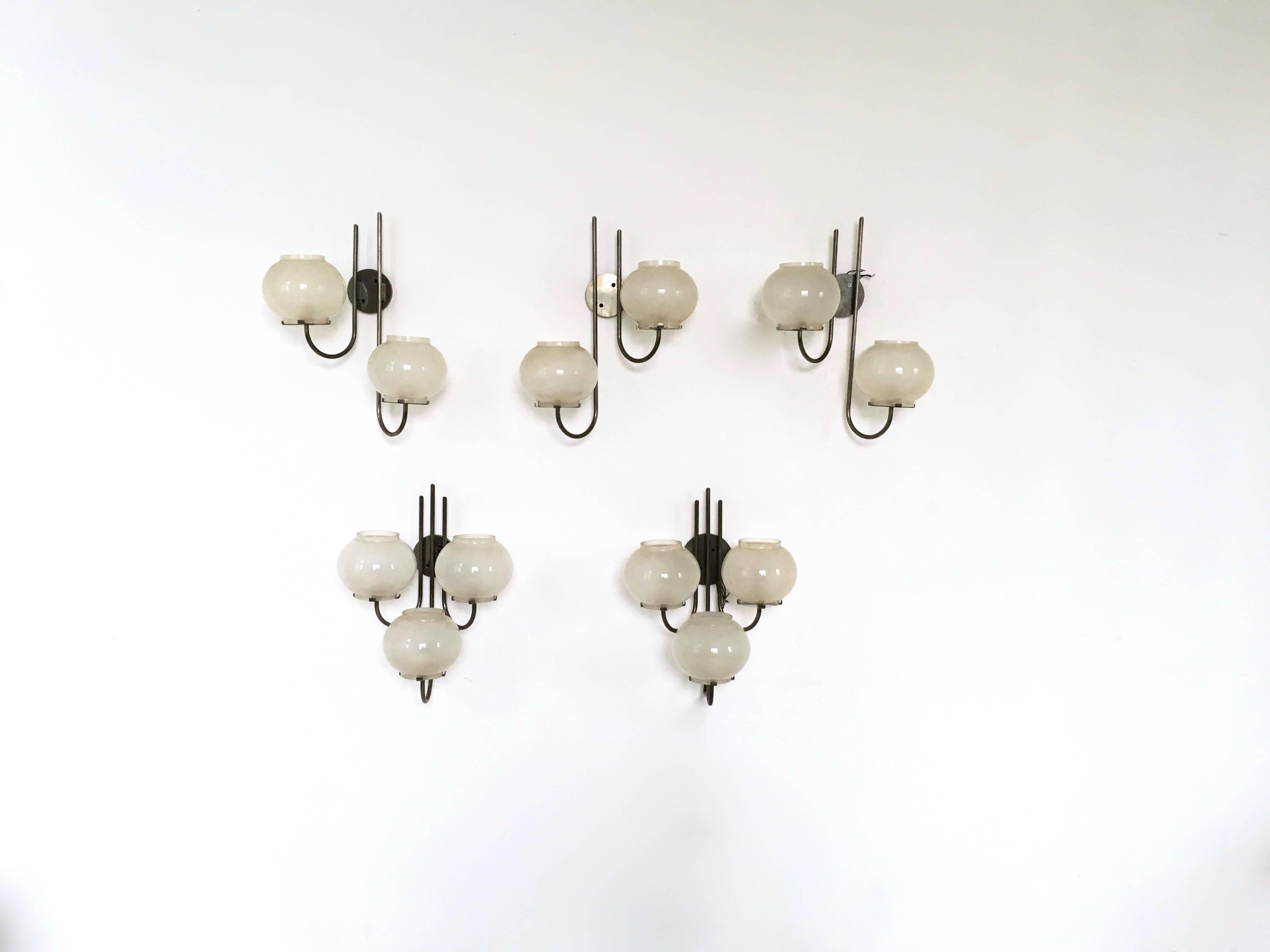 This is a set of three nickel-plated brass and frosted glass wall lights designed by Tito Agnoli and produced by O-Luce in 1961, Italy. 
These wall lights are vintage, therefore they might show slight traces of use, but they can be considered as in