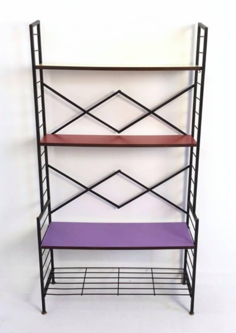 This shelving unit is made from varnished iron with brass feet caps and wooden shelves that are covered in formica.
It may show slight traces of use since it's vintage, but it can be considered as in excellent original condition and ready to become