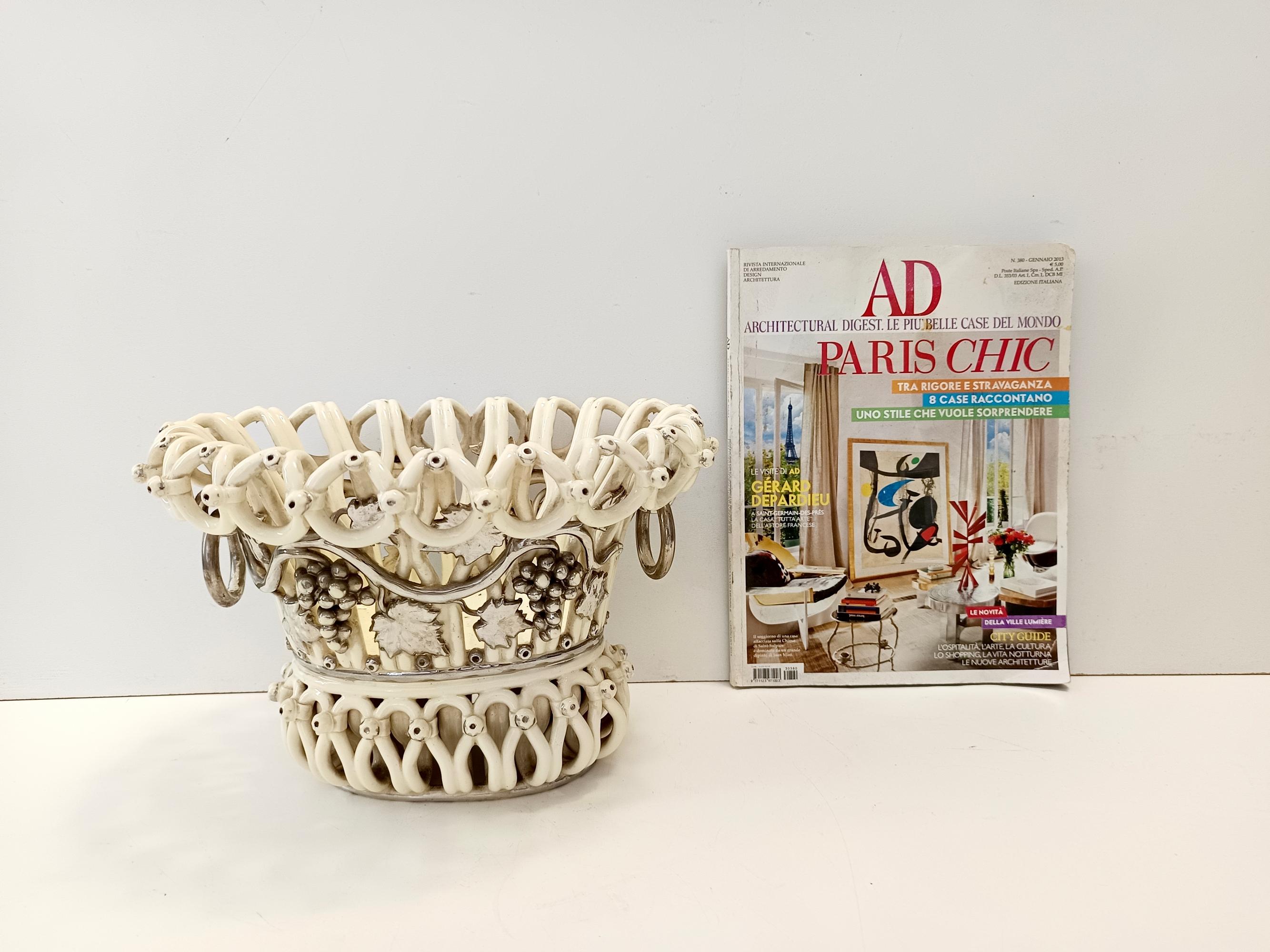 Fabriqué en France, 1850 env.
Cette coupe à fruits blanc crème avec cadre enroulé et poignées à anneaux mobiles argentés est réalisée en céramique émaillée et argentée. 
Il présente un riche décor appliqué de branches de vigne et de lianes.
Il
