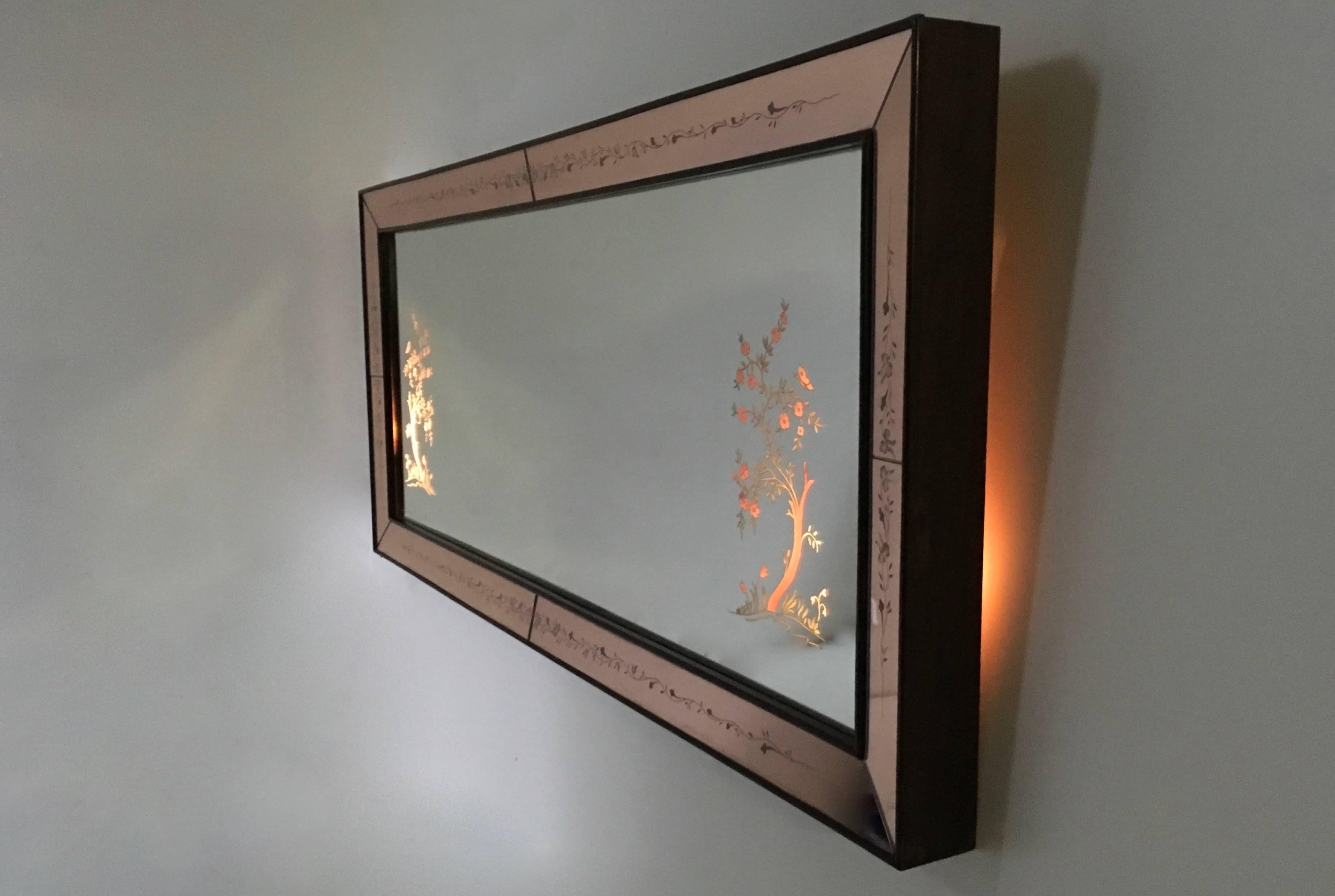 This is a very beautiful wall mirror. 
It is originally from 1940s.
Made from decorated glass and back-illuminated. 
In excellent condition.
 