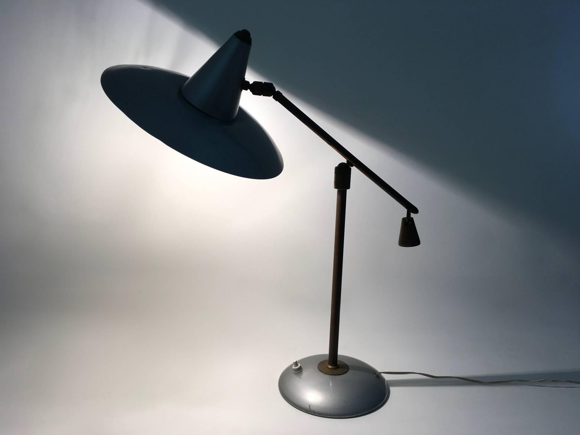 Made in Italy, 1950s.
It features a brass and varnished metal structure.
This desk lamp is vintage, therefore it might show slight traces of use, but it can be considered as in very good original condition.

Measures: 
Diameter 16 cm 
Height 51
