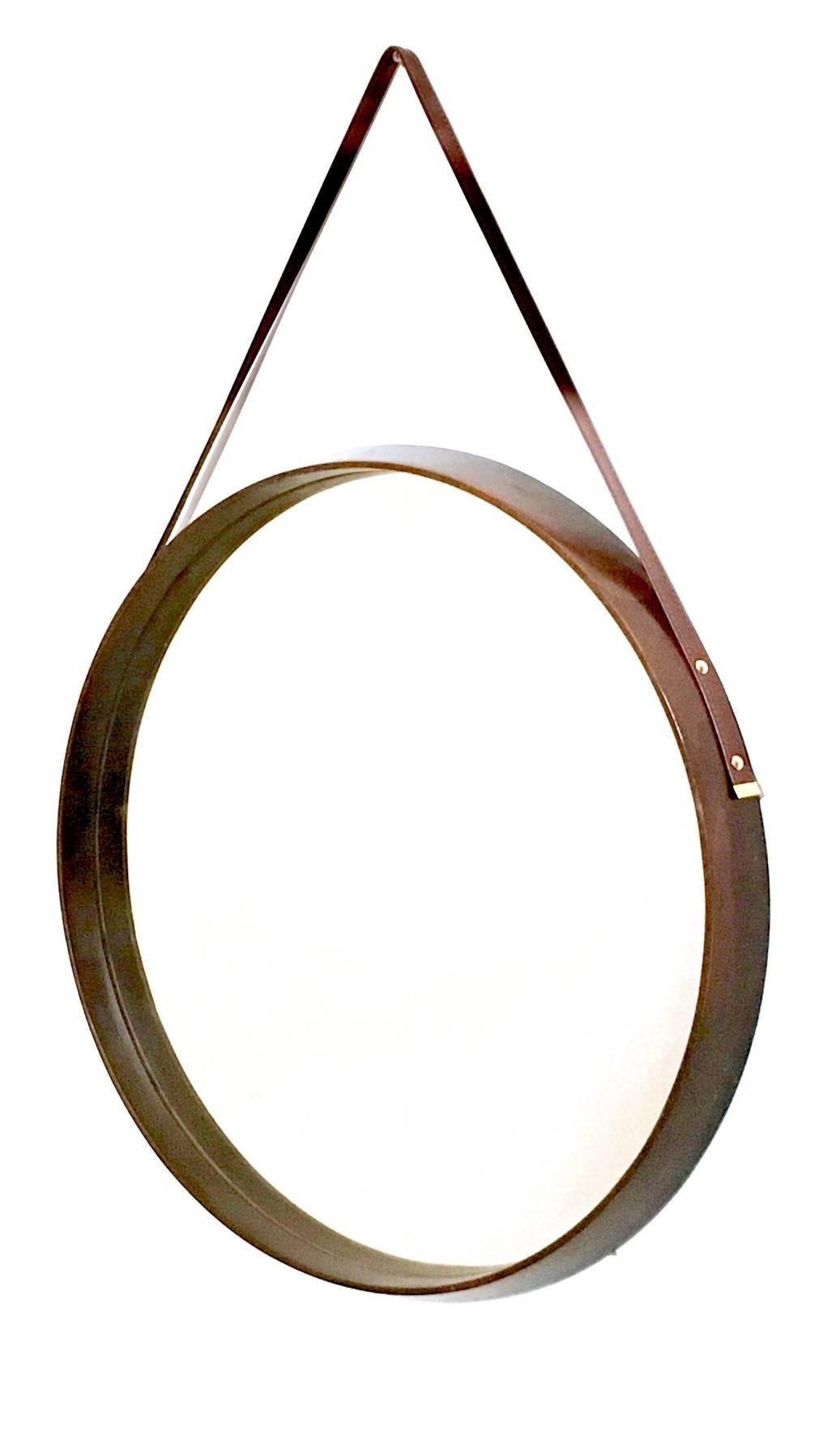 Made in brass, solid mahogany, mirror and leather.
The structure is in wood.
In perfect condition, as we replaced the leather with new one.
 
Measures: 
Diameter 51 cm
Depth 4 cm