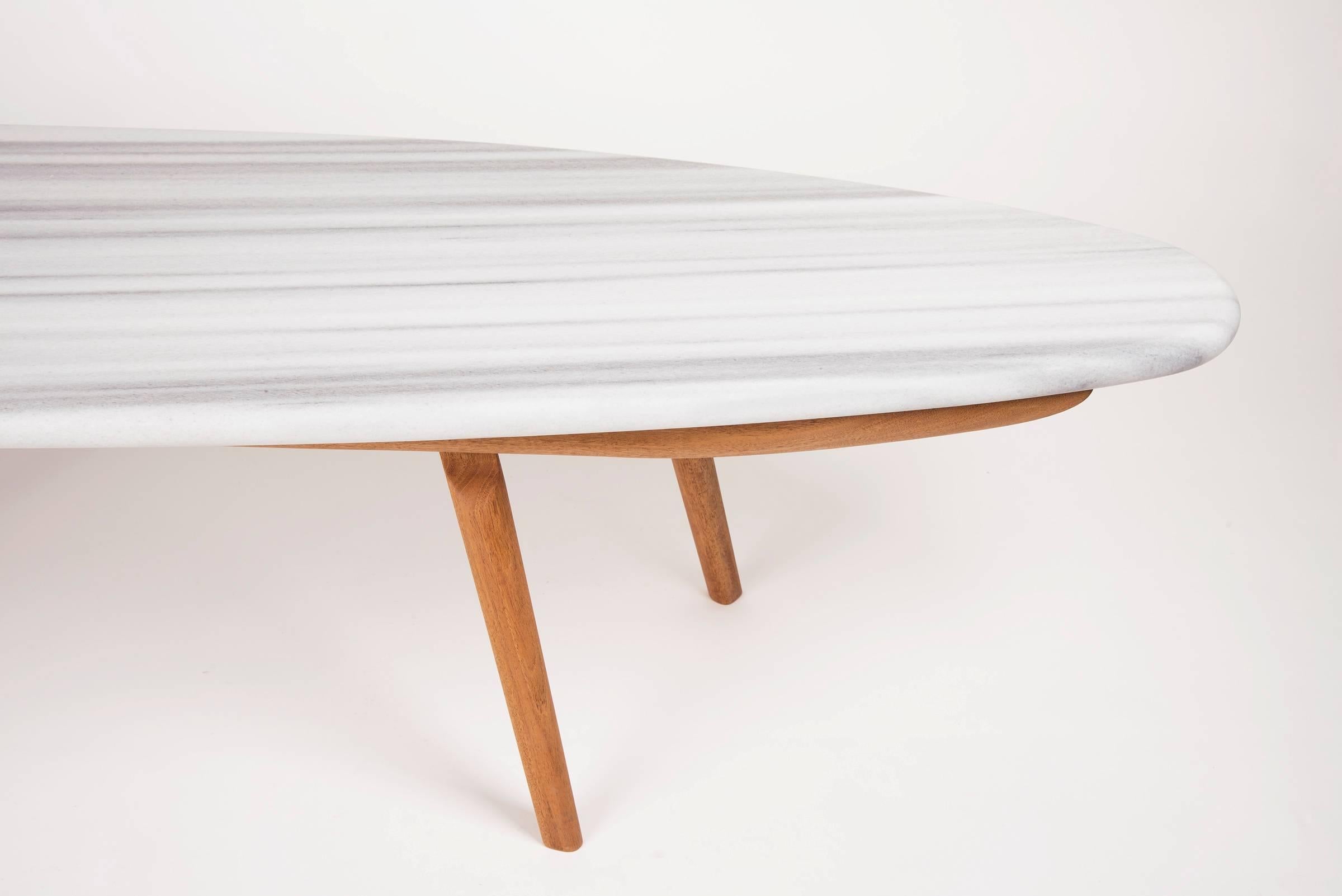In a similar spirit to the skip table, the Wendel table's form is inspired by hydrodynamics. Like a large stone in a moving body of water, the Wendel Table holds its place in any setting. The honed Zebra marble and oiled Mahogany give a strong