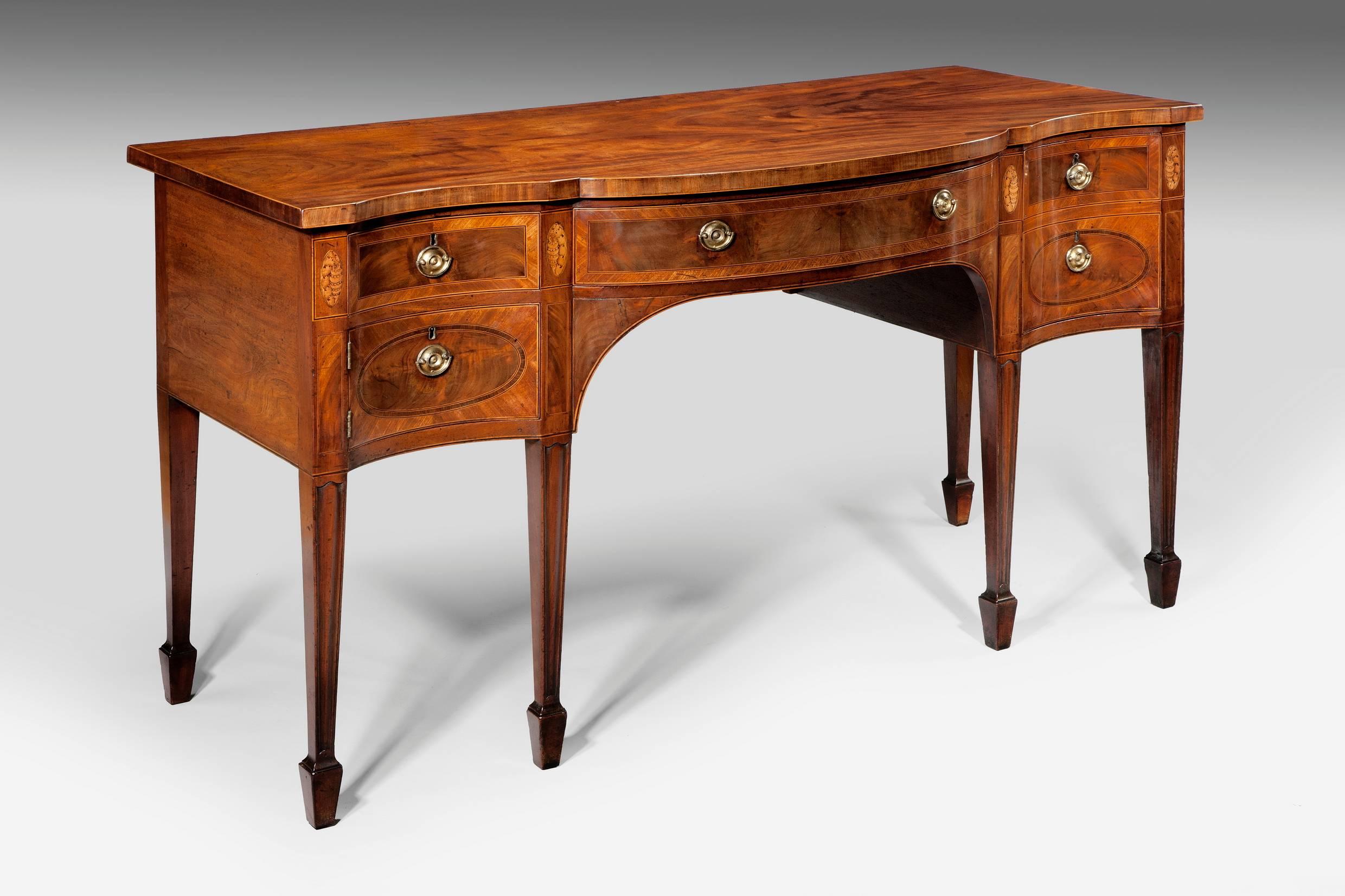Made from best quality and well figured Cuban mahogany, this sideboard is feather banded throughout on the drawer fronts and retains the original decorative marquetry inlay. It has a central drawer, a deep cellaret drawer and an opening cupboard