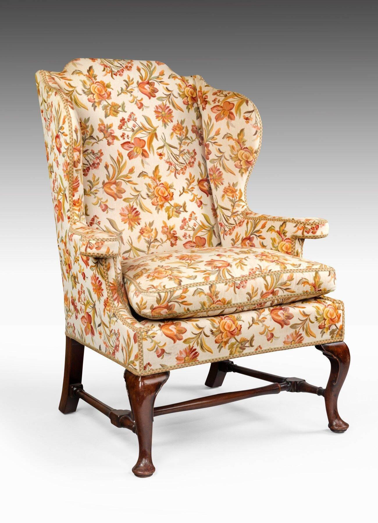 This pair of wing armchairs have great scale and most importantly, are comfortable to sit in. They have well shaped frames and an unusual arm. The mahogany front legs are cabriole in form and the legs are joined by a turned stretcher. The frames are